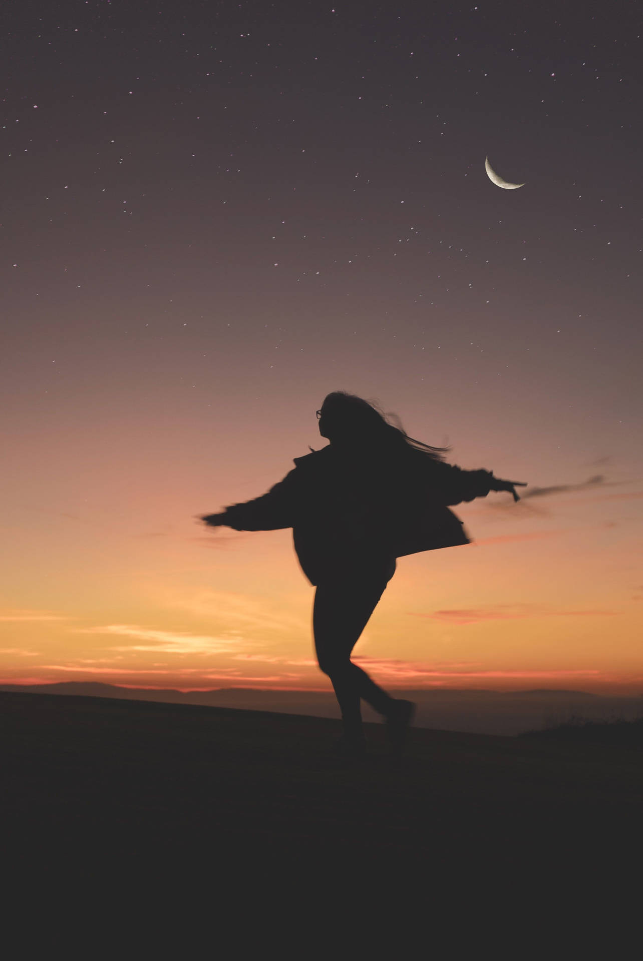 Silhouette 桌布 壁紙 — 一個剪影人物在一個佈滿星星和彎月的暮色天空下，在山丘上快樂地跳舞。