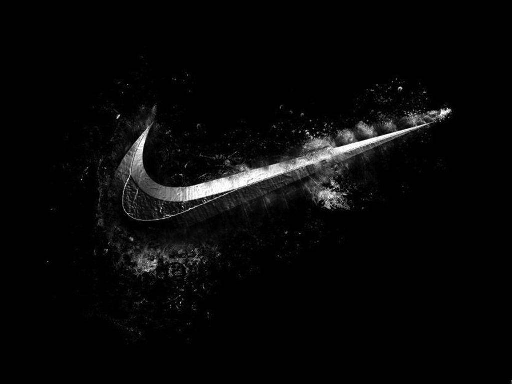 Nike 桌布 壁紙 — 一個動態的Nike swoosh標誌從白色粉末的爆發中浮現，背景是純黑色。