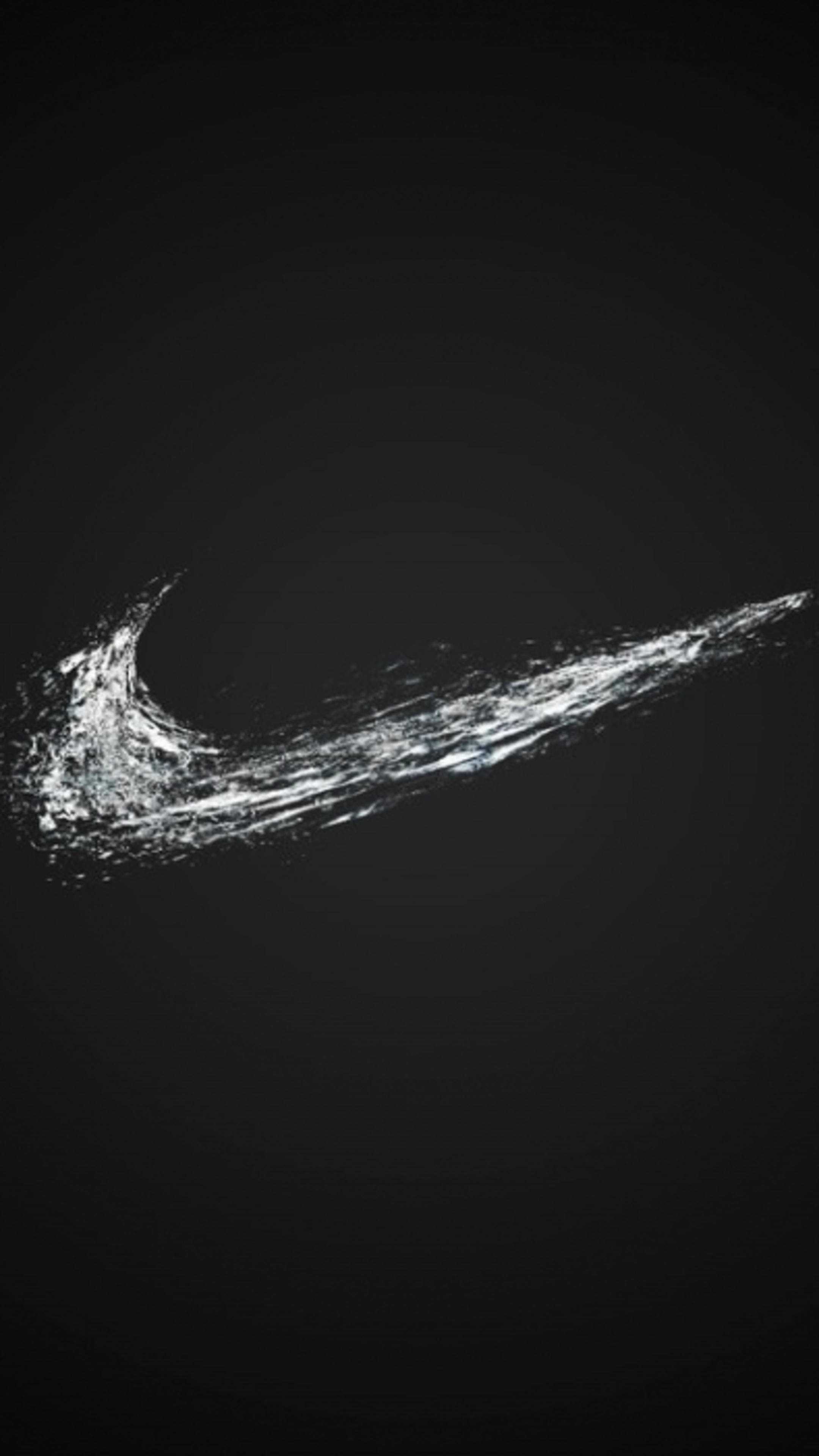 Nike 桌布 壁紙 — 一個動態的白色Nike勾勾標誌，由飛濺的水花在純黑背景上形成。