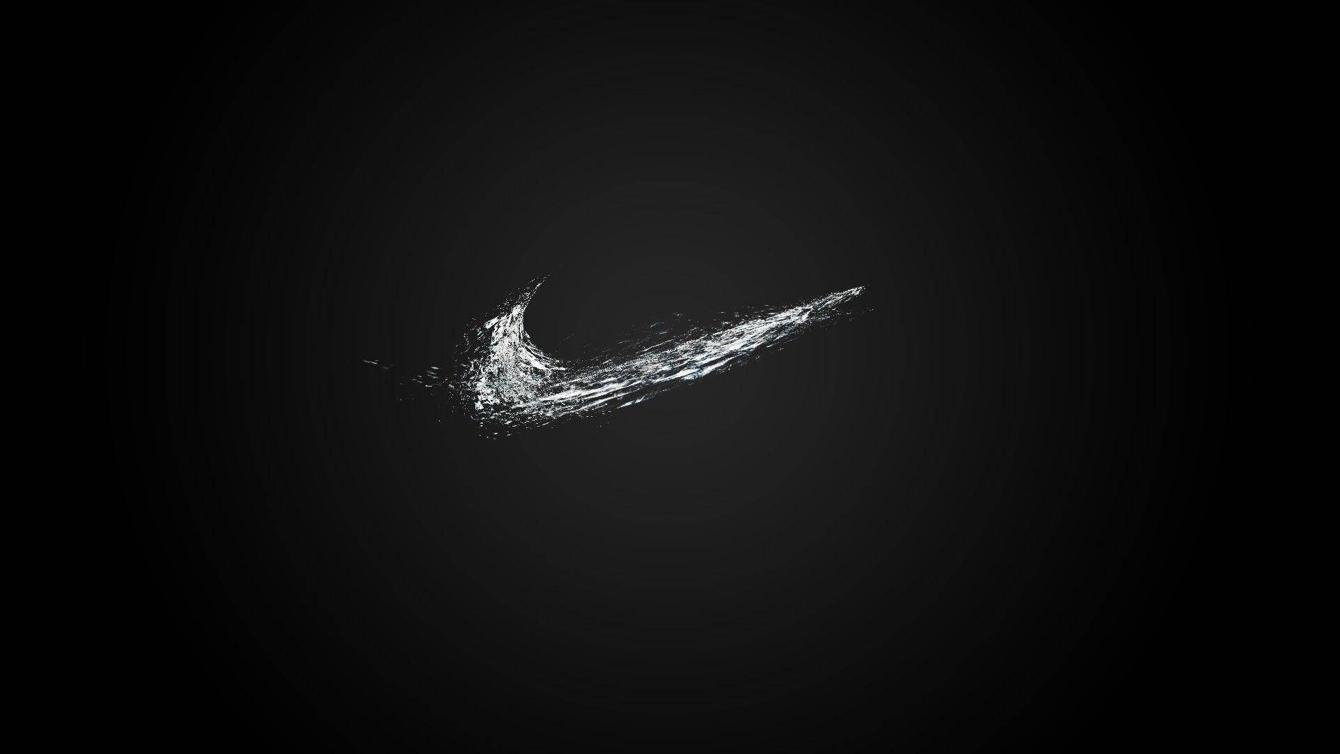酷黑 桌布 壁紙 — 一個動態的白色Nike勾號標誌，由飛濺的水在深色漸變背景上形成。