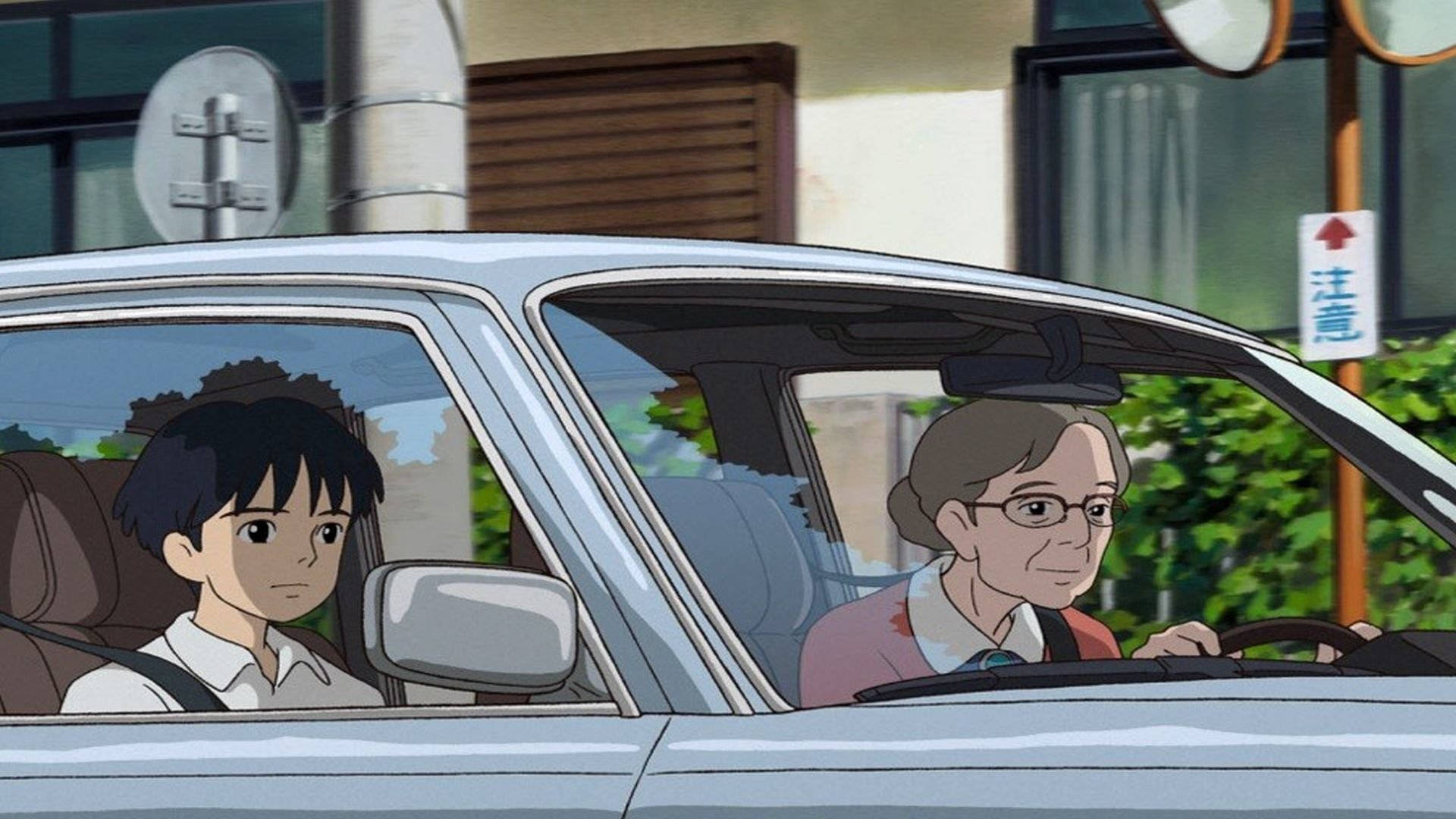 Arrietty 桌布 壁紙 — 一個動漫場景，顯示一個小男孩坐在乘客座位上，一位老婦人駕駛一輛銀色汽車穿過陽光明媚的城市街道。