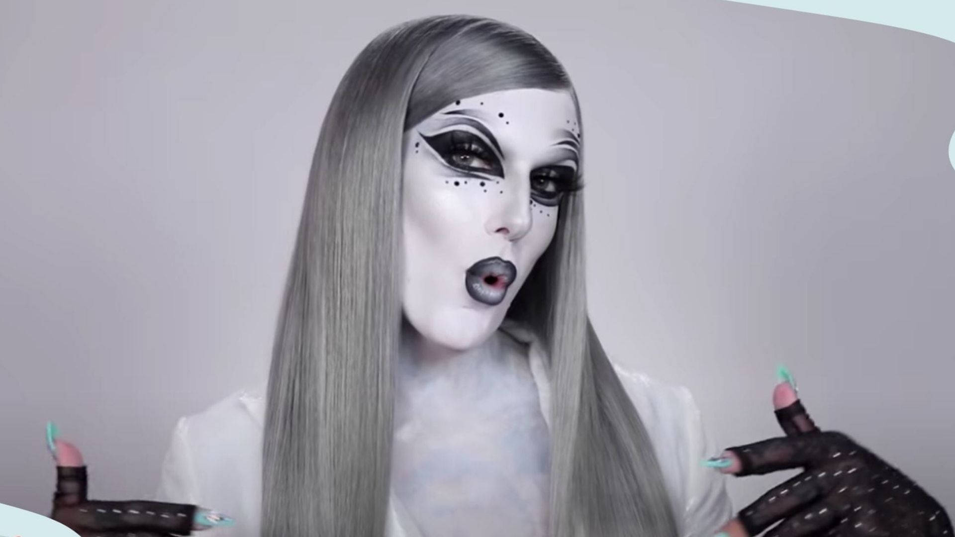 Jeffree Star 桌布 壁紙 — 一個化著蒼白妝容、留著長銀髮的人，戴著手套舉起雙手，露出驚訝的表情。
