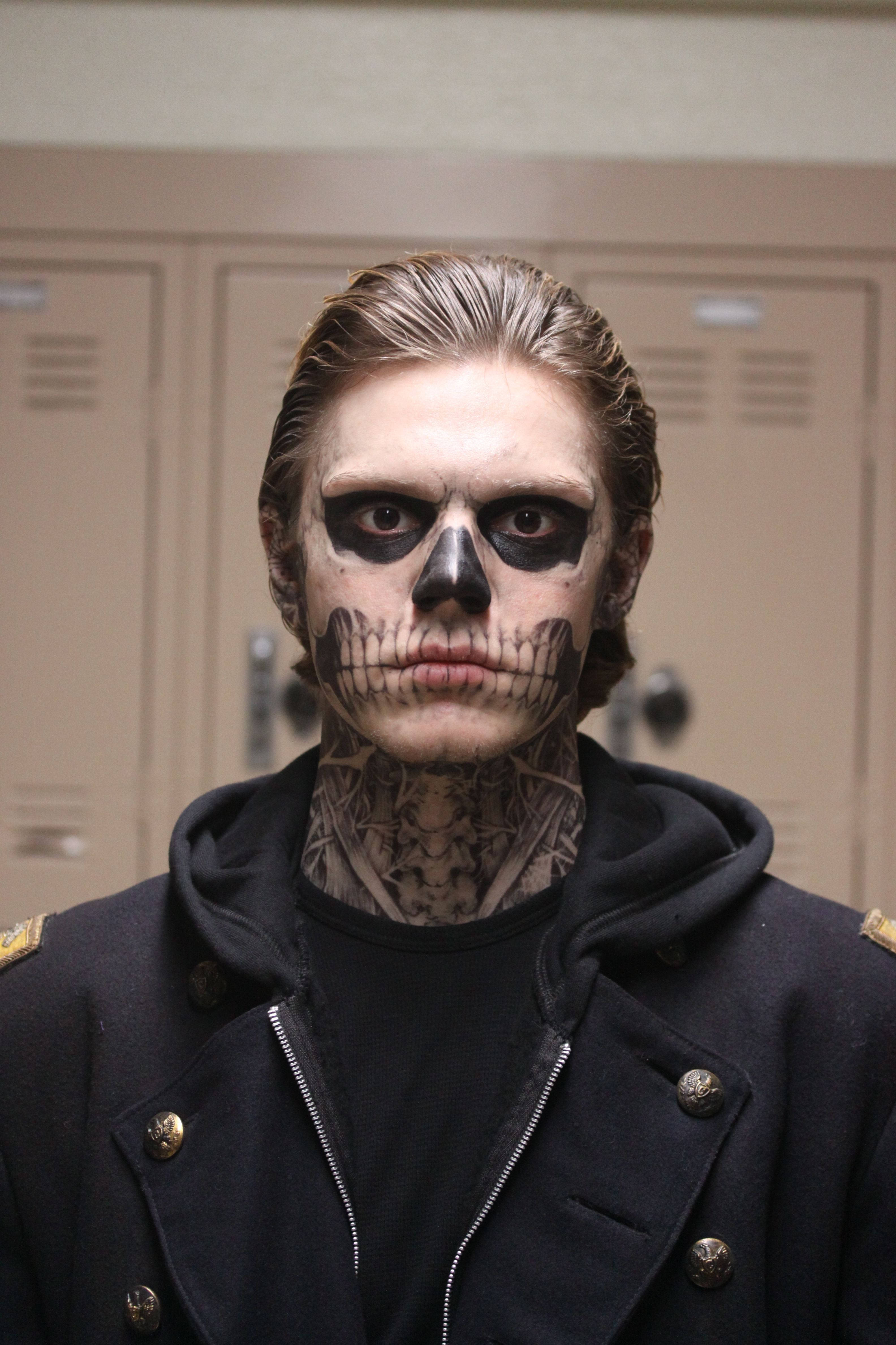 Tate Langdon 桌布 壁紙 — 一個化著骷髏妝容及頸部有刺青的人，在學校更衣室內凝視著。
