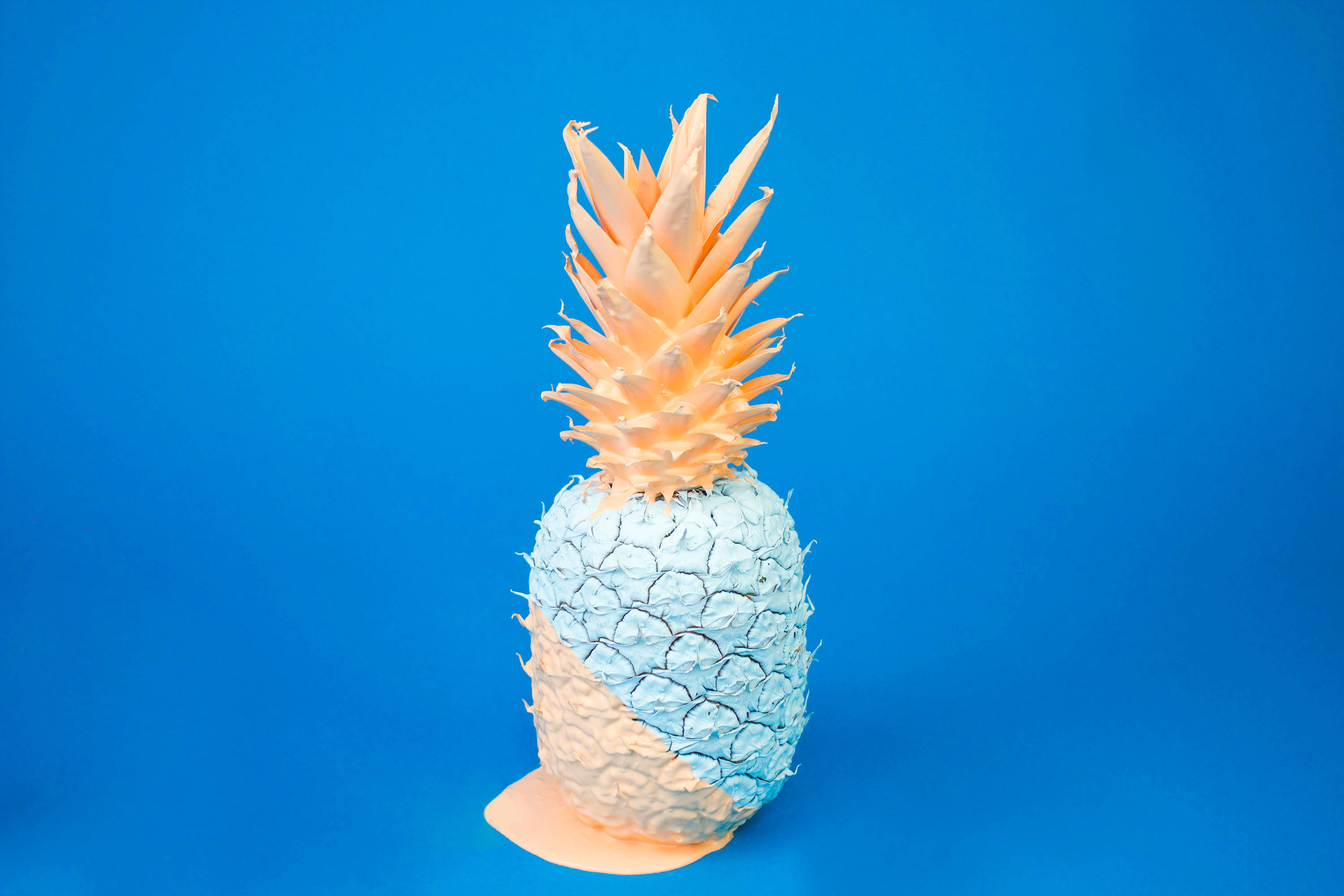 Pineapple 桌布 壁紙 — 一個半身塗成淺藍色的鳳梨，站在純藍色背景前。