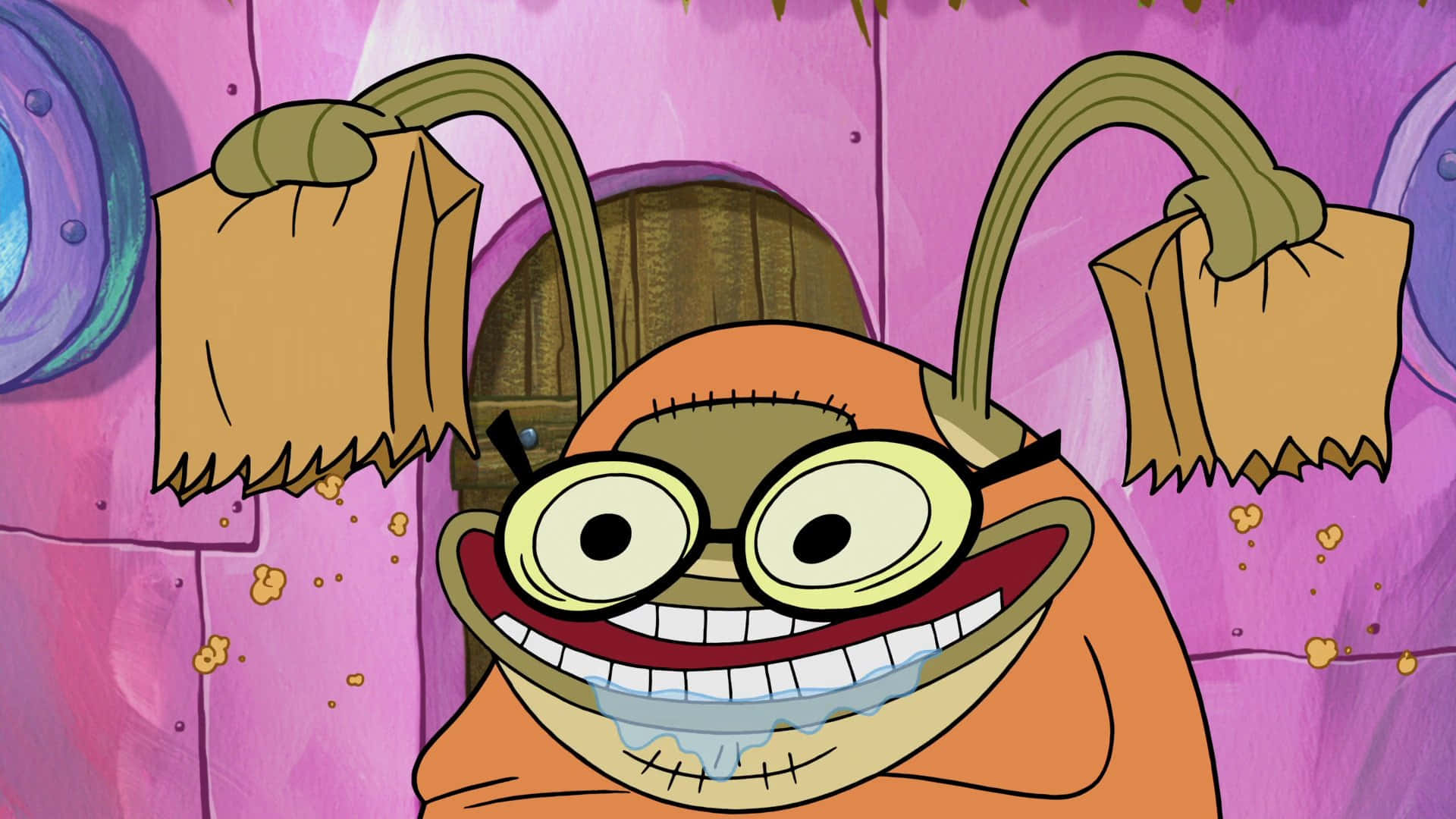 Bubble Bass 桌布 壁紙 — 一個卡通橙色生物，戴著超大眼鏡，咧嘴大笑，站在粉紅色紋理牆前，牆上掛著袋子。