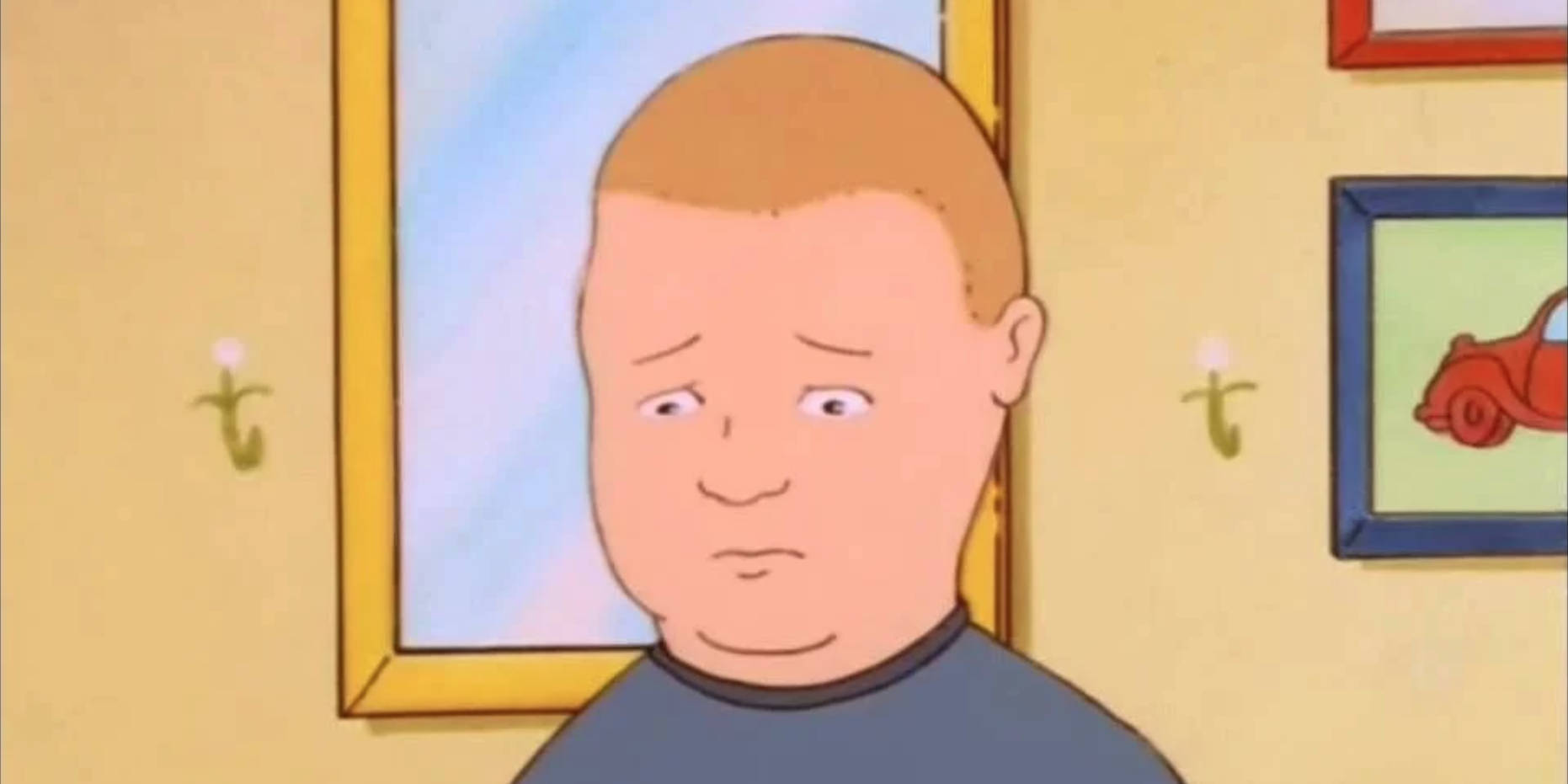 Bobby Hill 桌布 壁紙 — 一個卡通男孩帶著無聊的表情站在一個溫暖照明的房間裡，牆上掛著帶框的圖片。
