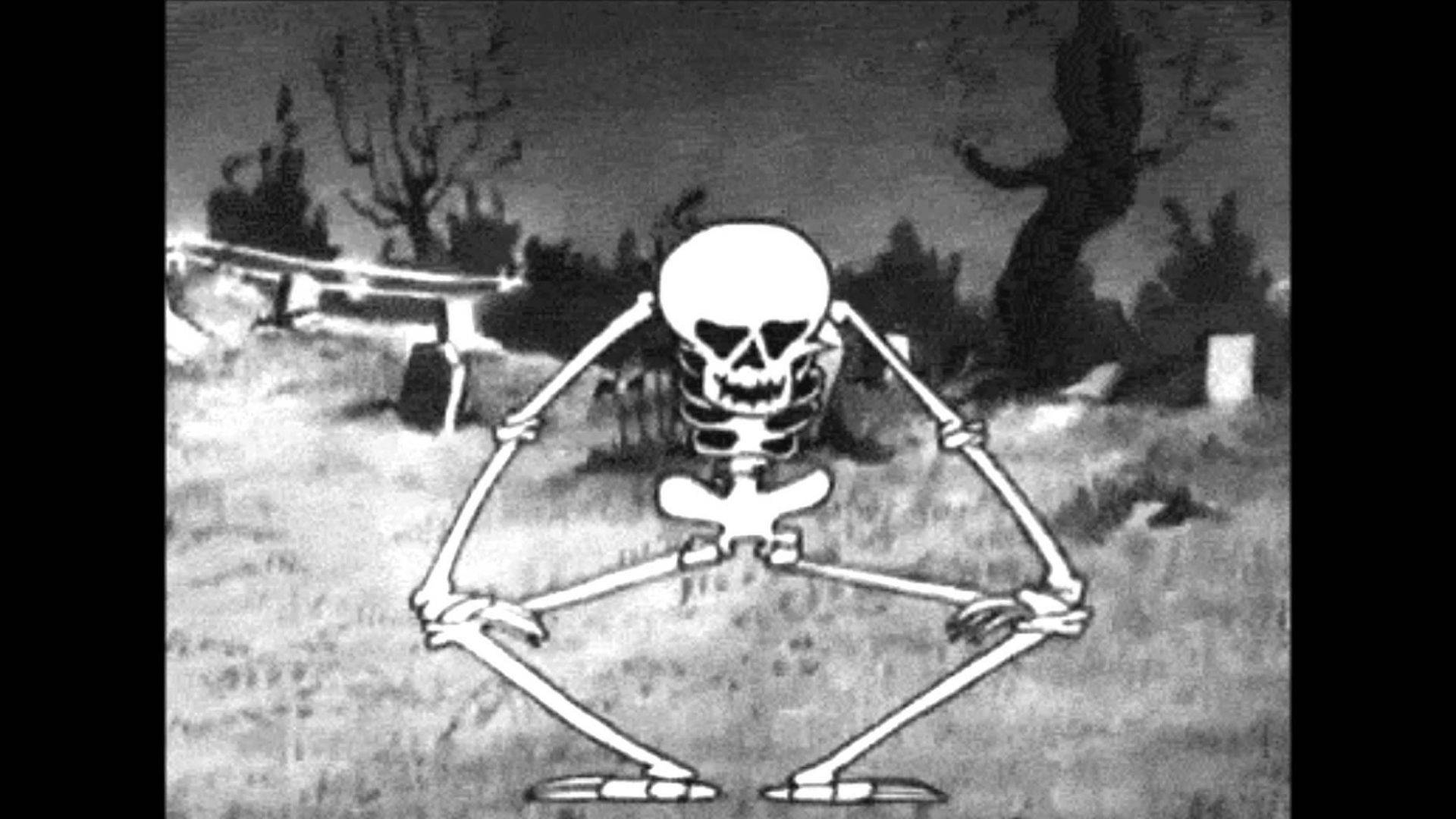 Skeleton Meme 桌布 壁紙 — 一個卡通骷髏在黑暗天空下，盤腿坐在一個有裸樹和墓碑的陰森墓地裡。
