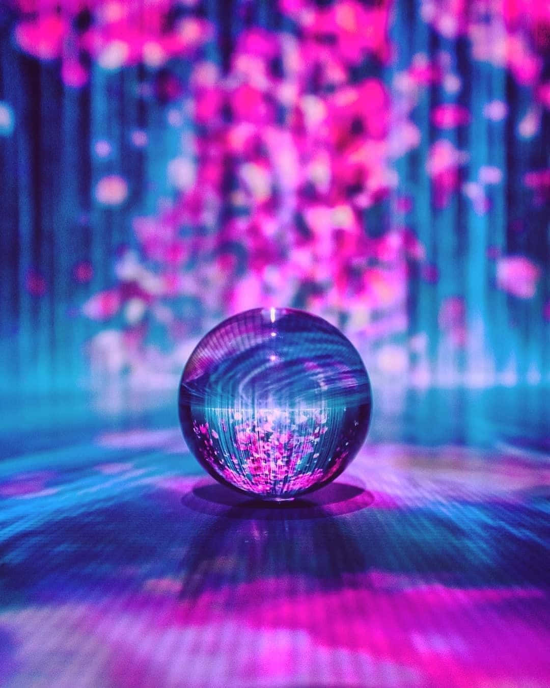Crystal Ball 桌布 壁紙 — 一個反射玻璃球在未來主義的數位藝術裝置中捕捉充滿活力的粉紅色和藍色光束。
