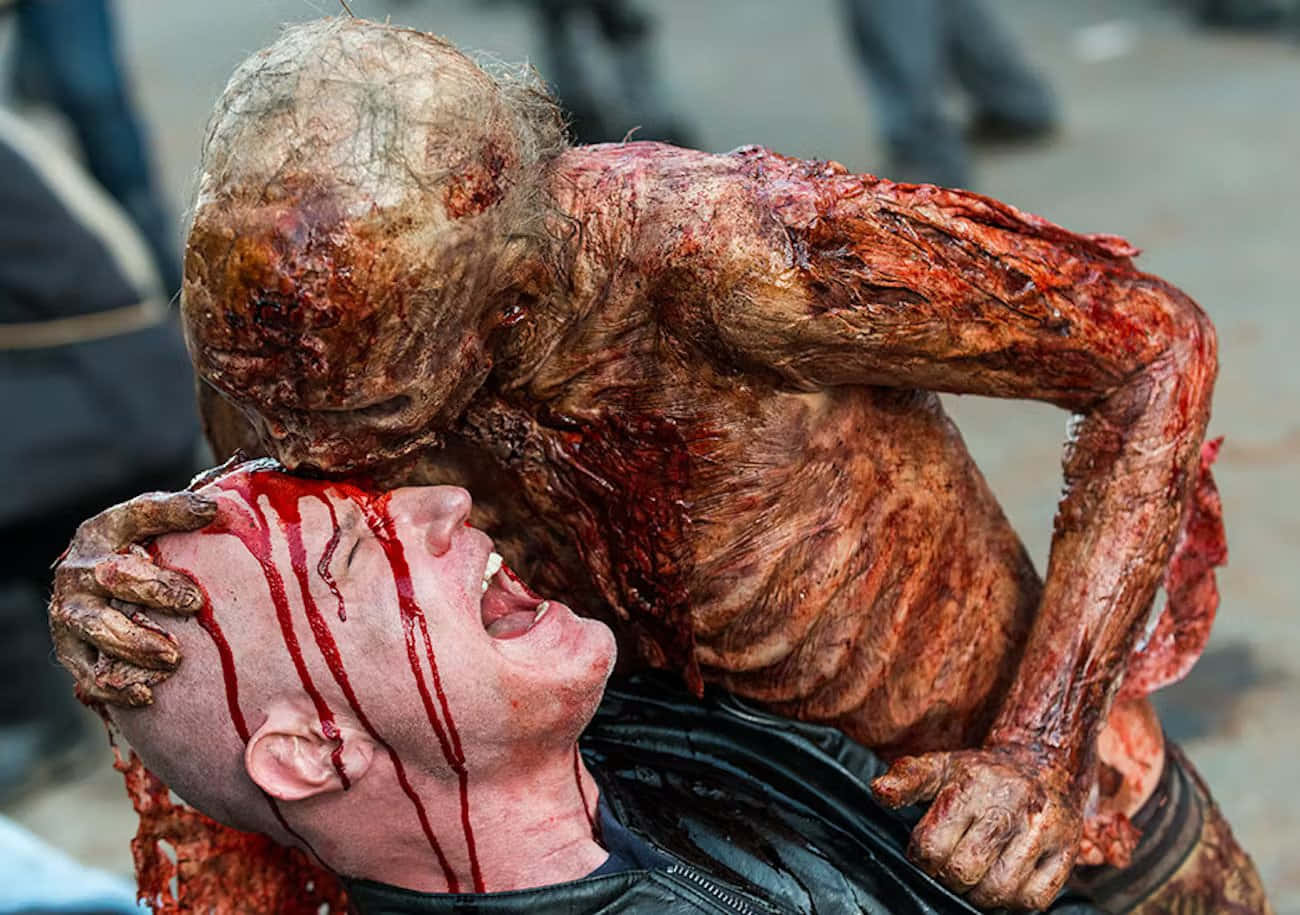 walking dead 桌布 壁紙 — 一個可怕的殭屍，撕裂的肉和血淋淋的手，在血腥的特寫中抓住尖叫受害者的頭。