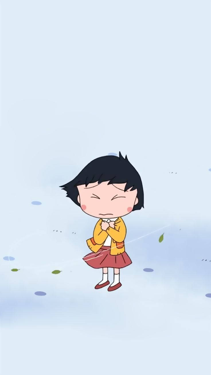 Chibi Maruko Chan 桌布 壁紙 — 一個可愛的動漫女孩，穿著黃色外套和紅色裙子，在柔和的藍色背景前閉著眼睛顫抖，周圍有落葉。