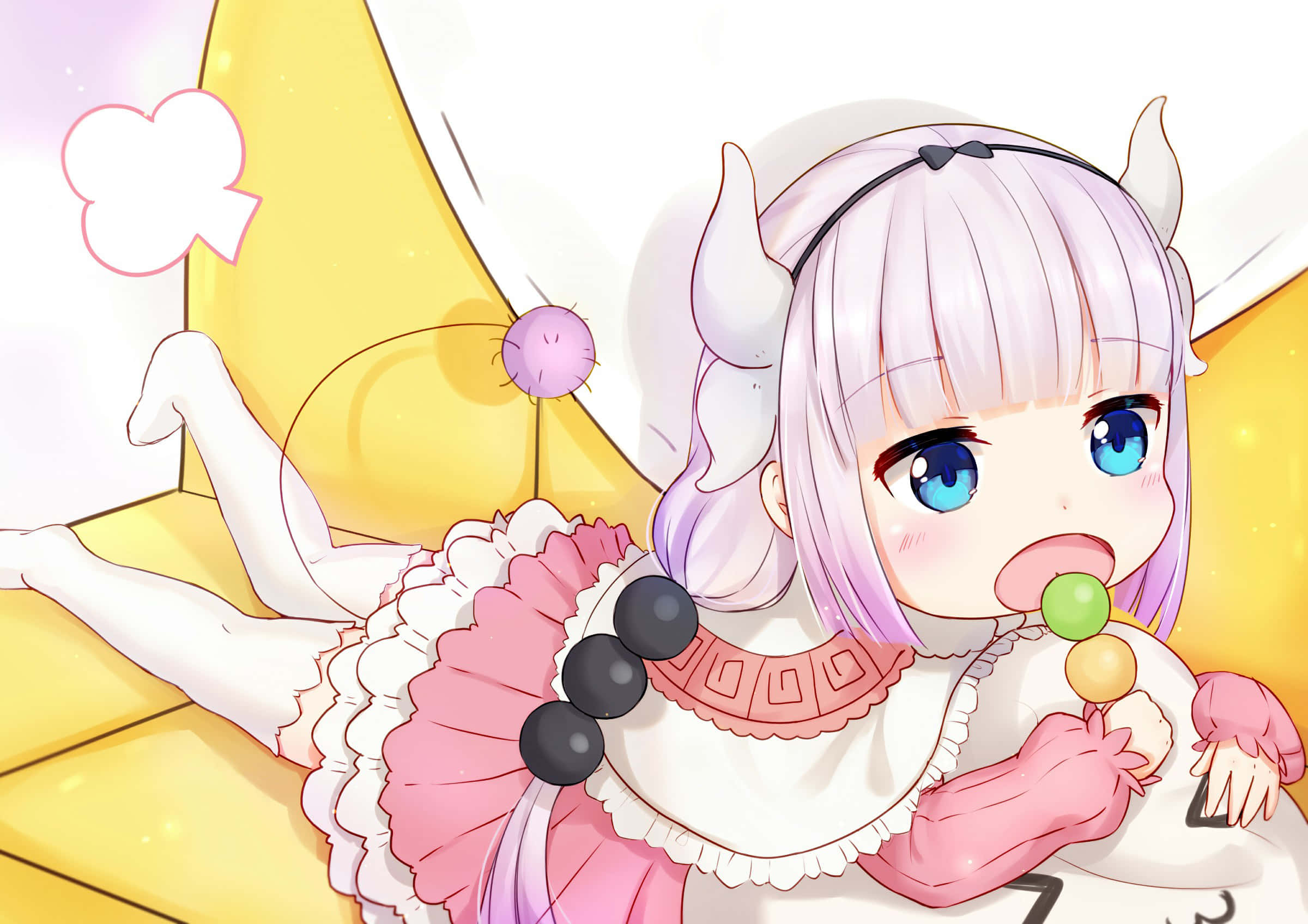 Kanna Kamui 桌布 壁紙 — 一個可愛的動漫女孩，粉紅色頭髮和角，躺在黃色沙發上，開心地吃著彩色棒棒糖。