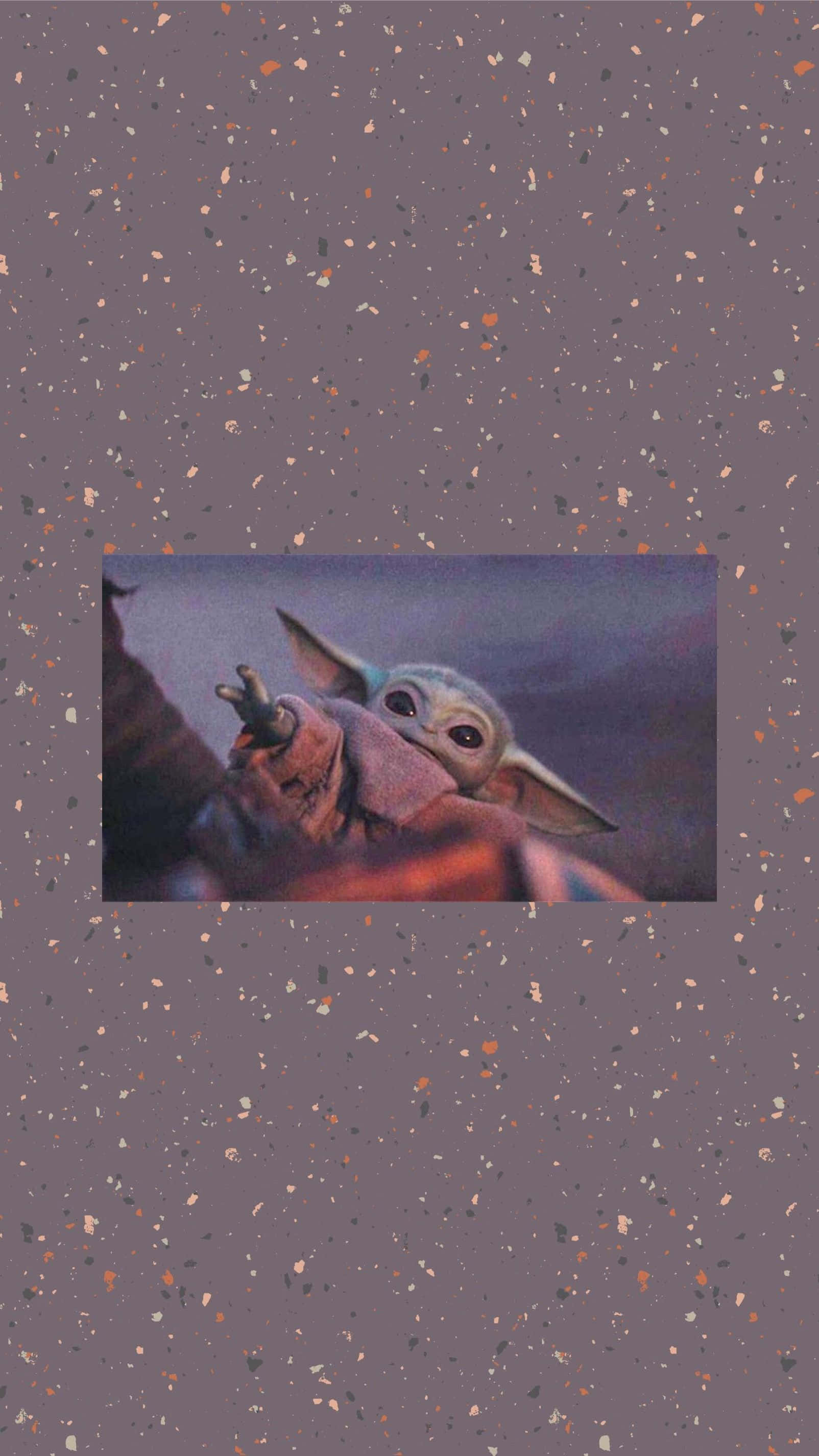 Baby Yoda Phone 桌布 壁紙 — 一個可愛的嬰兒尤達從紅色斗篷中探出頭來，背景是斑點紫色。