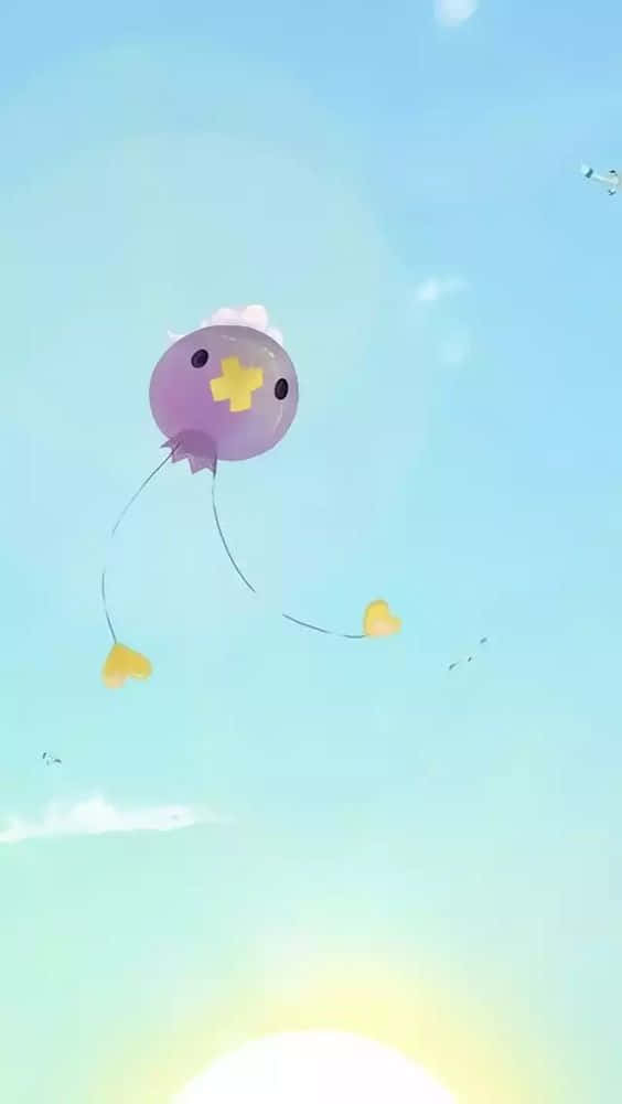 Pokemon Aesthetic 桌布 壁紙 — 一個可愛的紫色氣球角色，帶有黃色十字架，在明亮的藍天中輕輕漂浮，伴隨著柔軟的雲朵和燦爛的太陽。