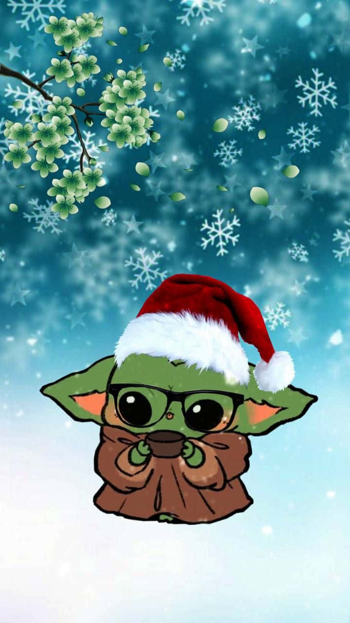 Cartoon Yoda 桌布 壁紙 — 一個可愛的綠色嬰兒尤達戴著紅色聖誕帽和眼鏡，在飄雪和綠色花朵的雪藍色背景前拿著一個杯子。