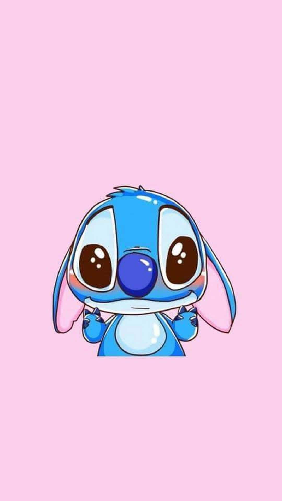 Cartoon Characters 桌布 壁紙 — 一個可愛的藍色卡通外星人，有大大的棕色眼睛和粉紅色耳朵，在柔和的粉紅色背景上微笑。