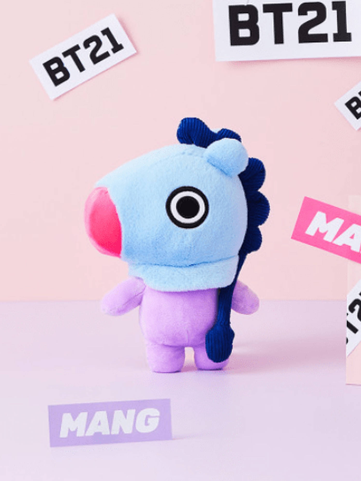 mang bt21 桌布 壁紙 — 一個可愛的藍色和紫色BT21毛絨玩具站在粉彩粉紅色背景前，背景散落著品牌貼紙。