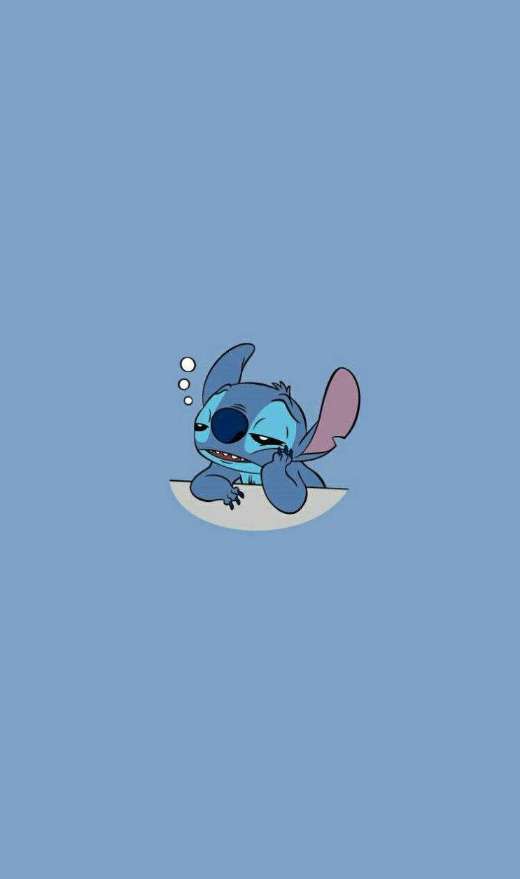 Cute Cartoon 桌布 壁紙 — 一個可愛的藍色外星人角色，閉上一隻眼睛，帶著一個思想泡泡，坐在白色平台上，背景是純藍色。