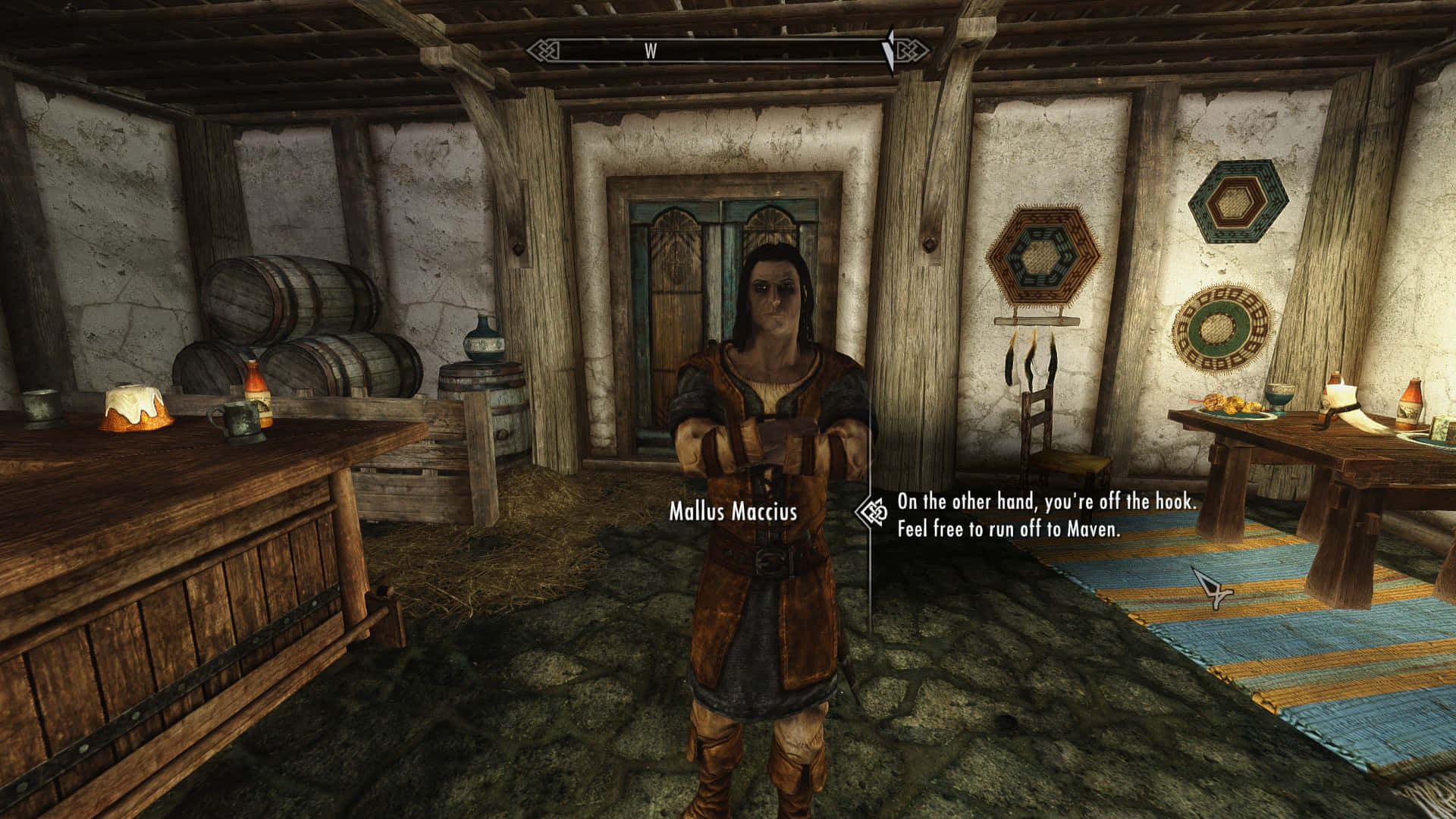 Thieves Guild 桌布 壁紙 — 一個名叫 Mallus Maccius 的角色站在一個有木桶、桌子和石地板的鄉村木製酒館中。