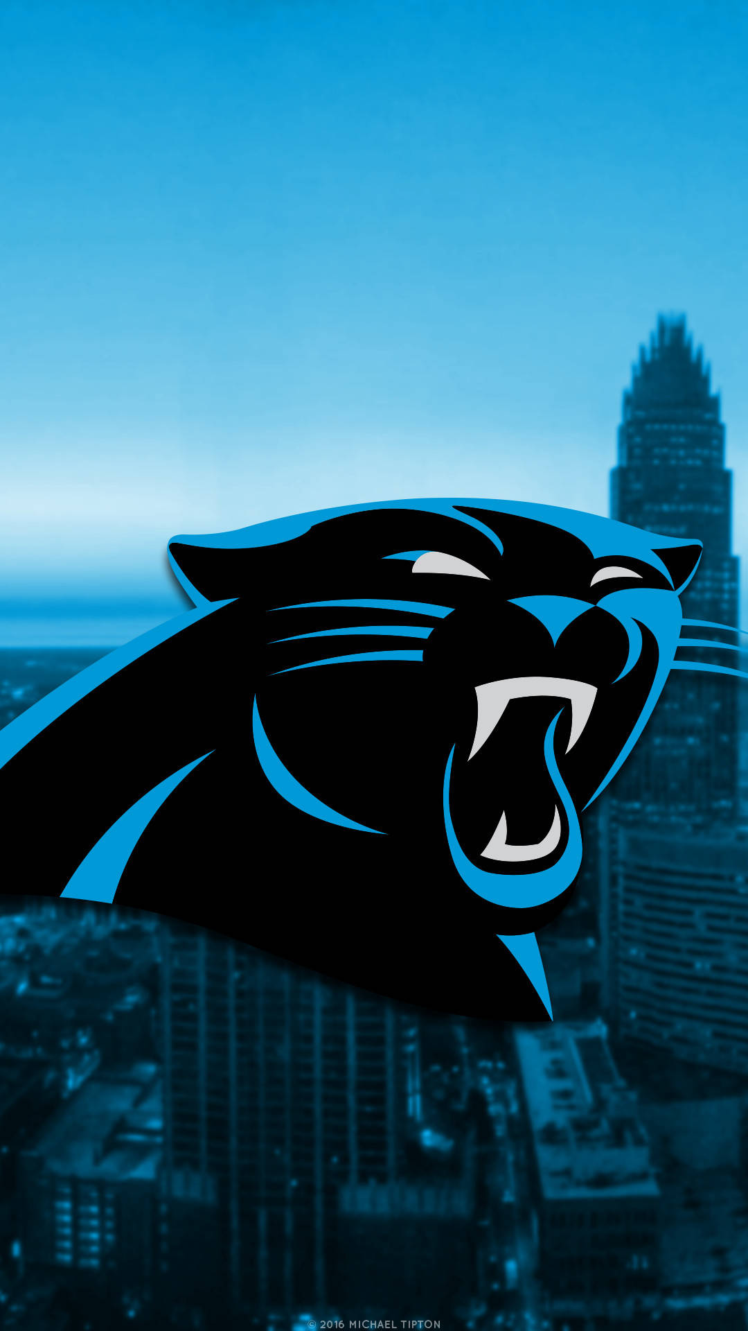 Panthers 桌布 壁紙 — 一個咆哮的黑豹標誌，帶有藍色點綴，主導了晴朗藍天下模糊的城市天際線。