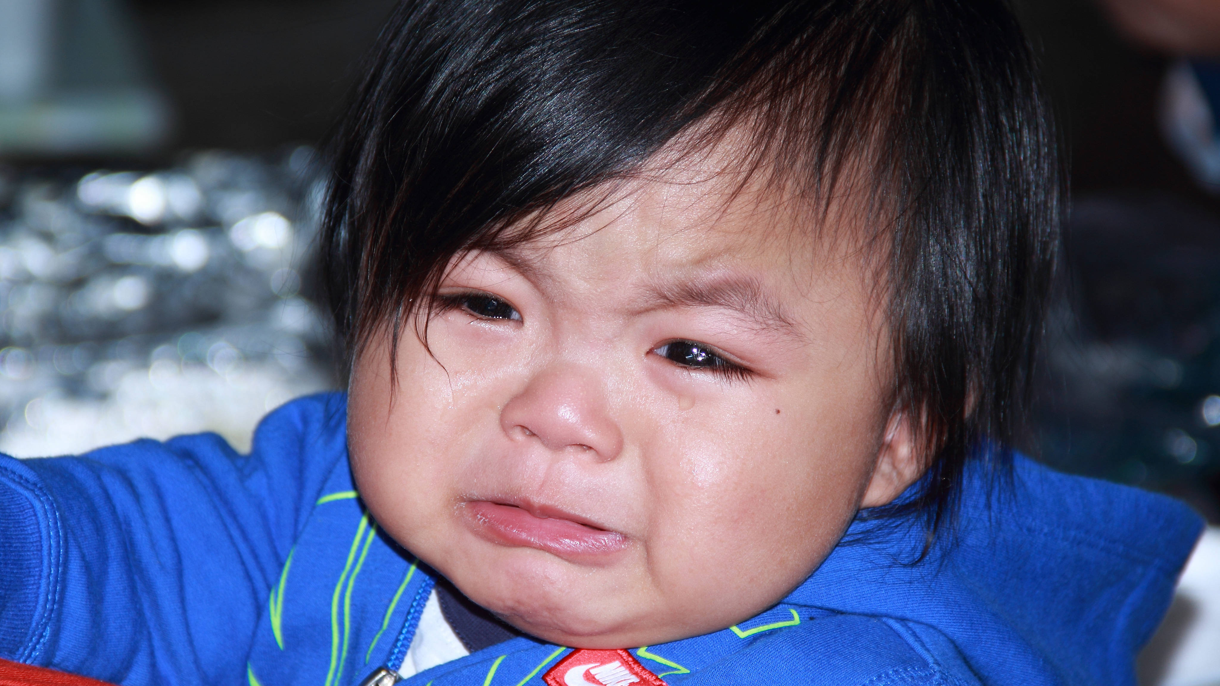 crying sad boy 桌布 壁紙 — 一個哭泣嬰兒的特寫，深色頭髮，穿著藍色外套，顯示淚眼汪汪和下垂的嘴巴。