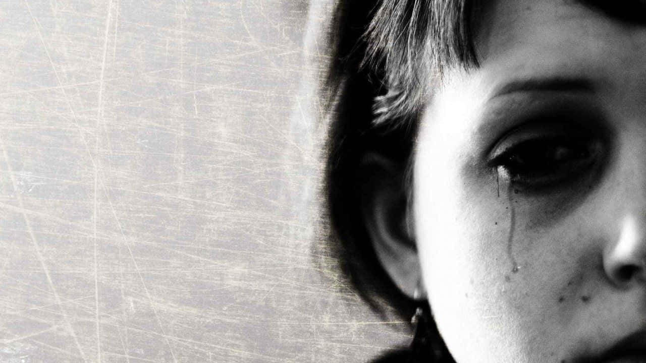 Depressed 桌布 壁紙 — 一個哭泣孩子的黑白特寫肖像，淚水順著臉頰流下，背景是帶有刮痕的紋理背景。
