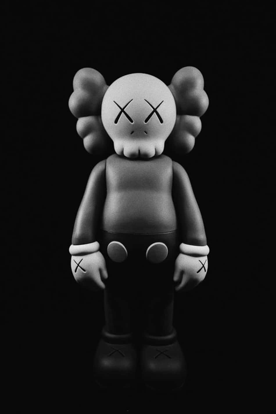 桌布 壁紙 — 一個單色KAWS Companion公仔，在純黑背景前莊嚴地站立，帶有X形眼睛和雙手。