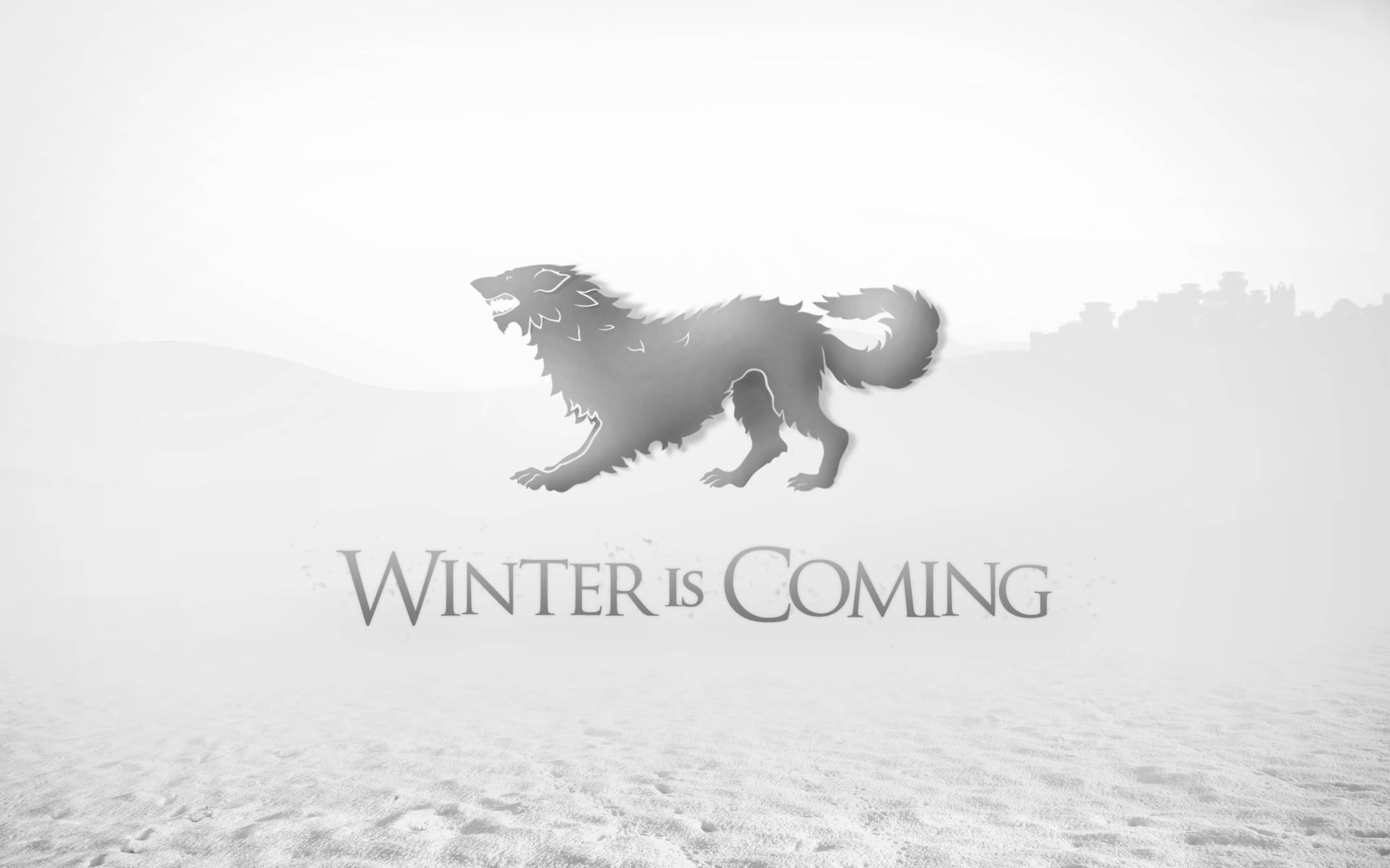 House Stark 桌布 壁紙 — 一個單色剪影，一隻咆哮的冰原狼在雪原上大步前行，下方是那句不祥的短語冬天來了。