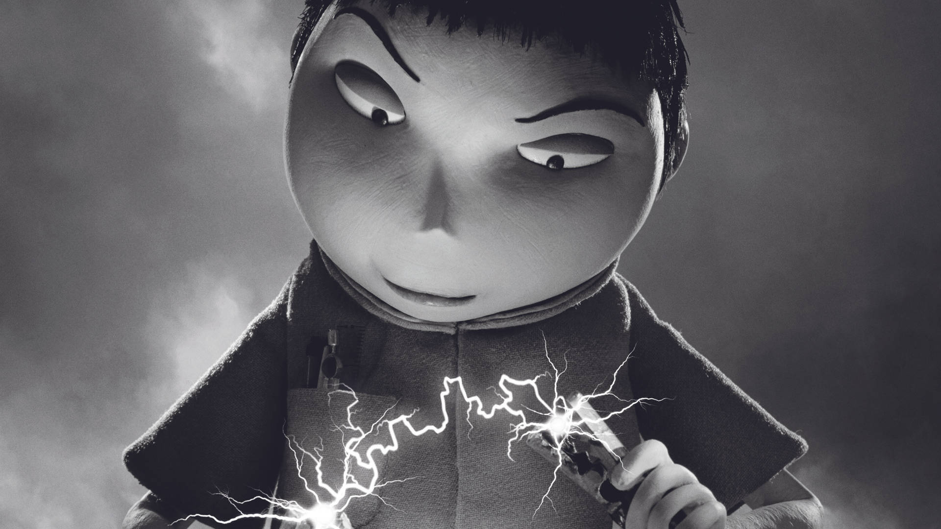 Frankenweenie 桌布 壁紙 — 一個單色動畫男孩，眼神銳利，手持一個迸發火花的裝置，背景煙霧彌漫。