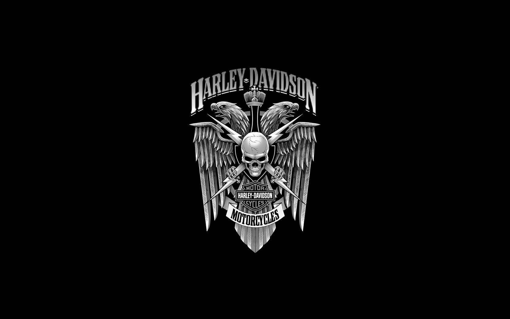 Harley 桌布 壁紙 — 一個單色哈雷戴維森標誌，包含一個帶翅膀的骷髏頭和交叉的劍，背景為黑色。