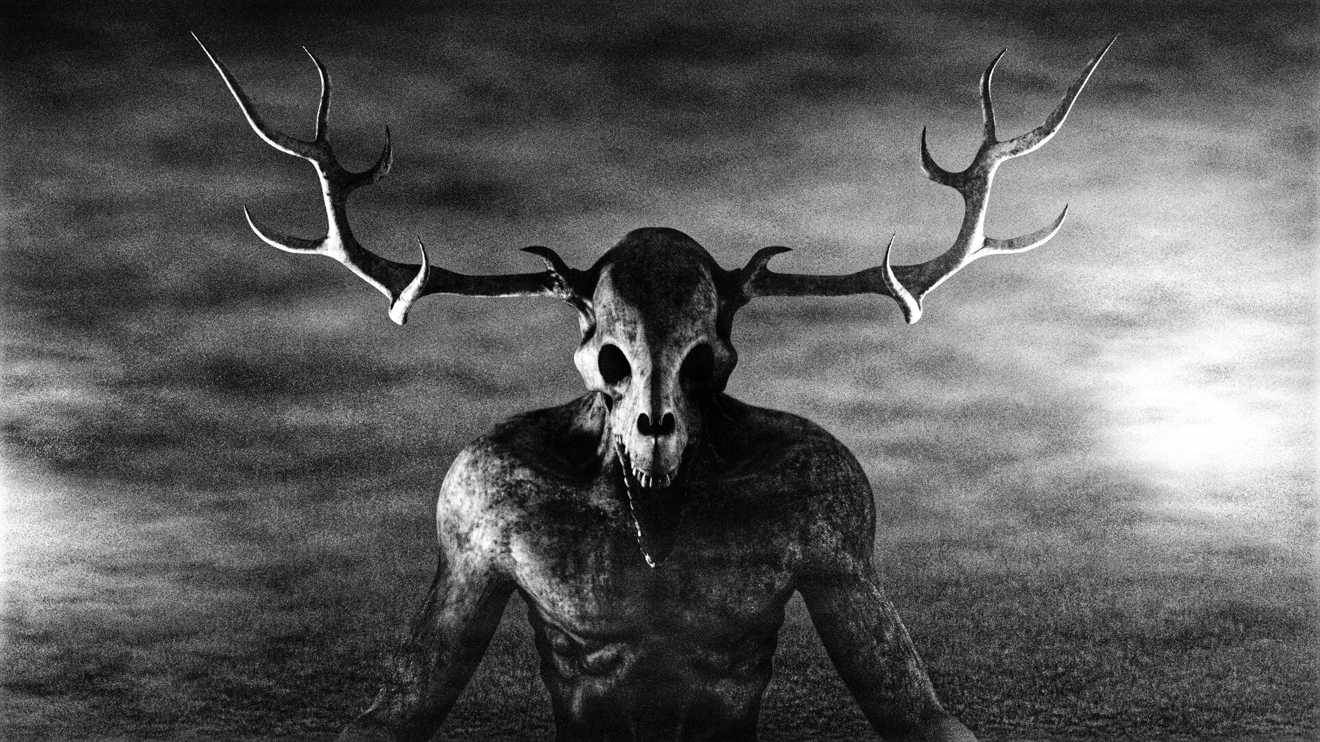 Wendigo 桌布 壁紙 — 一個單色恐怖角色，頭戴鹿頭骨和鹿角，在陰雲密布的天空下威嚇地站立。