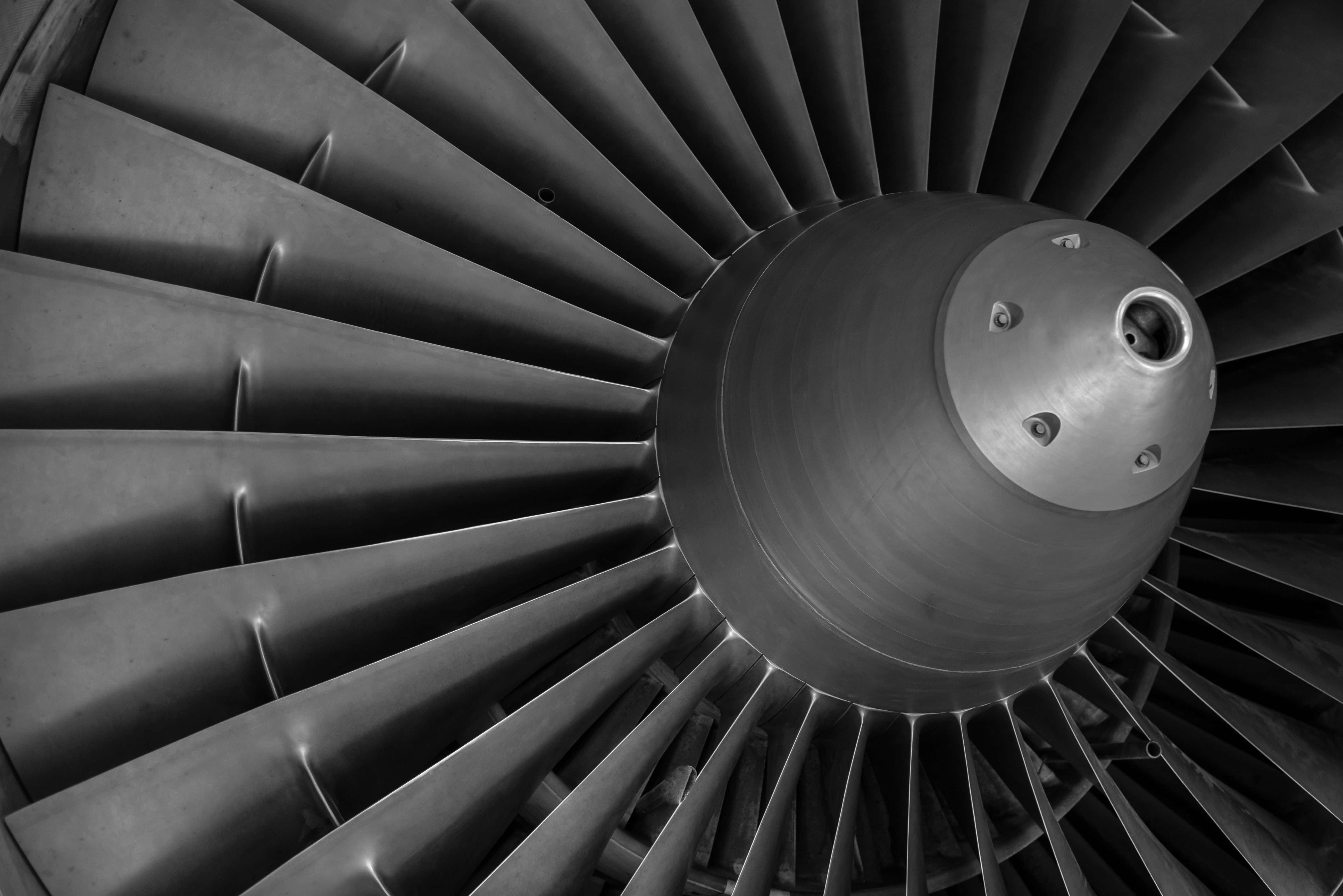 Jet Engine 桌布 壁紙 — 一個單色特寫的噴射引擎渦輪，帶有徑向葉片和中央輪轂，展現工業精準度。