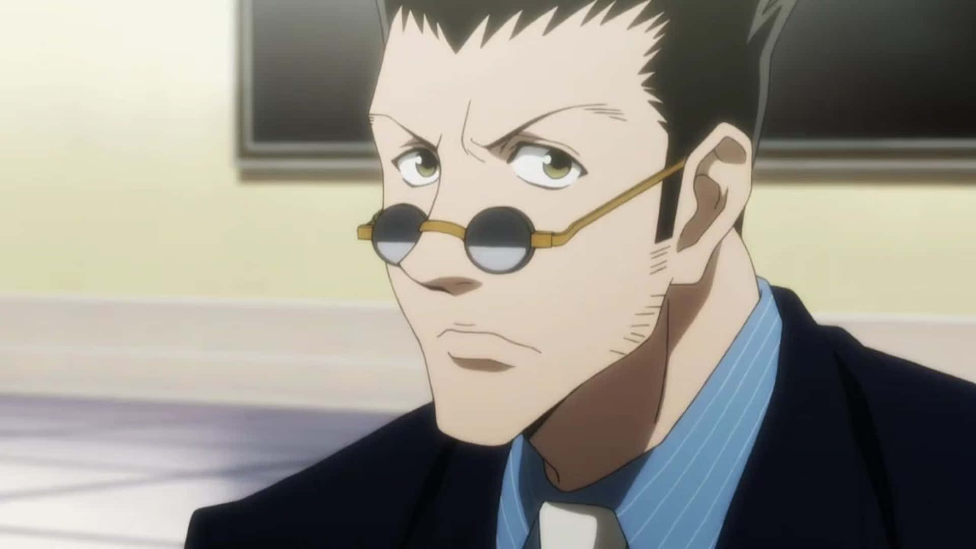 Leorio Paradinight 桌布 壁紙 — 一個嚴肅的動漫男人，戴著圓眼鏡，頭髮尖刺，穿著西裝，專注地向前凝視。