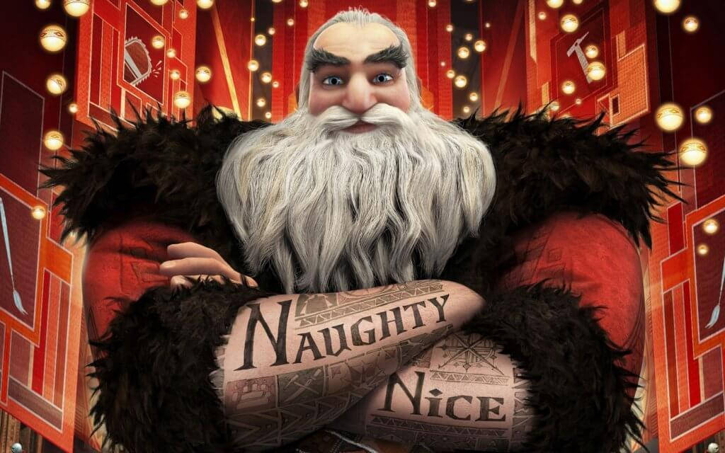 Santa Claus 桌布 壁紙 — 一個嚴肅的動畫聖誕老人，手臂上有刺青寫著「Naughty」和「Nice」，交叉雙臂站在節日紅金色劇院場景中。