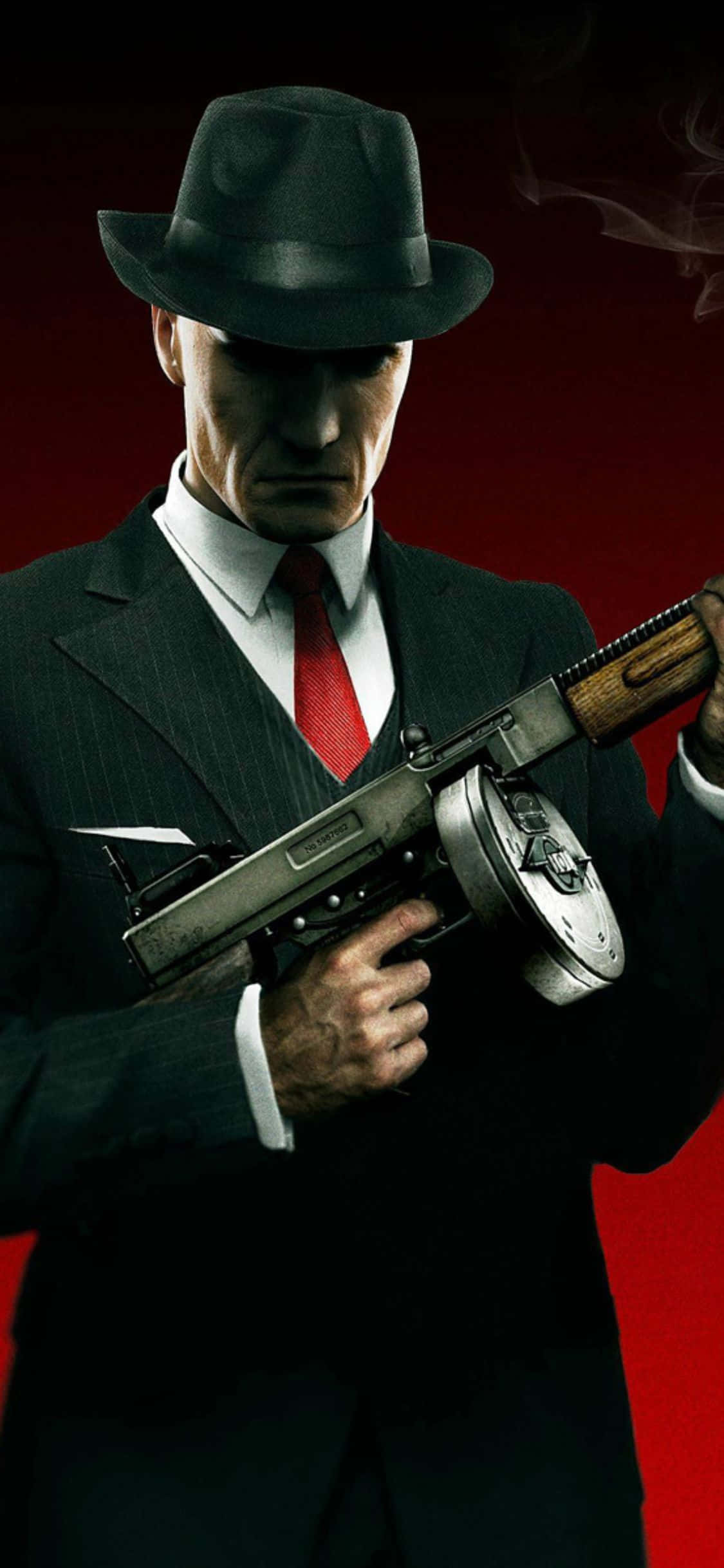 iPhone X Hitman Absolution 桌布 壁紙 — 一個嚴肅的男人戴著黑色軟呢帽、穿著西裝，在煙霧升起的鮮紅色背景前手持衝鋒槍。