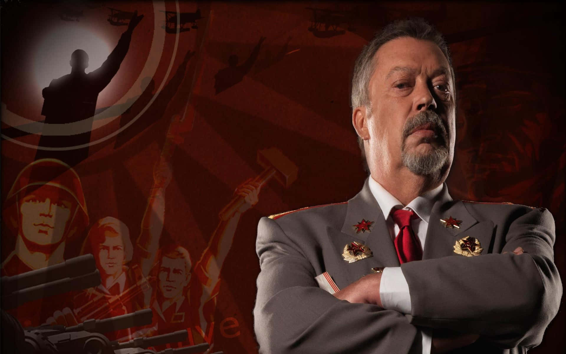 Tim Curry 桌布 壁紙 — 一個嚴肅的男人穿著裝飾華麗的軍服，雙臂交叉，站在帶有蘇聯式宣傳圖像的紅色背景前。