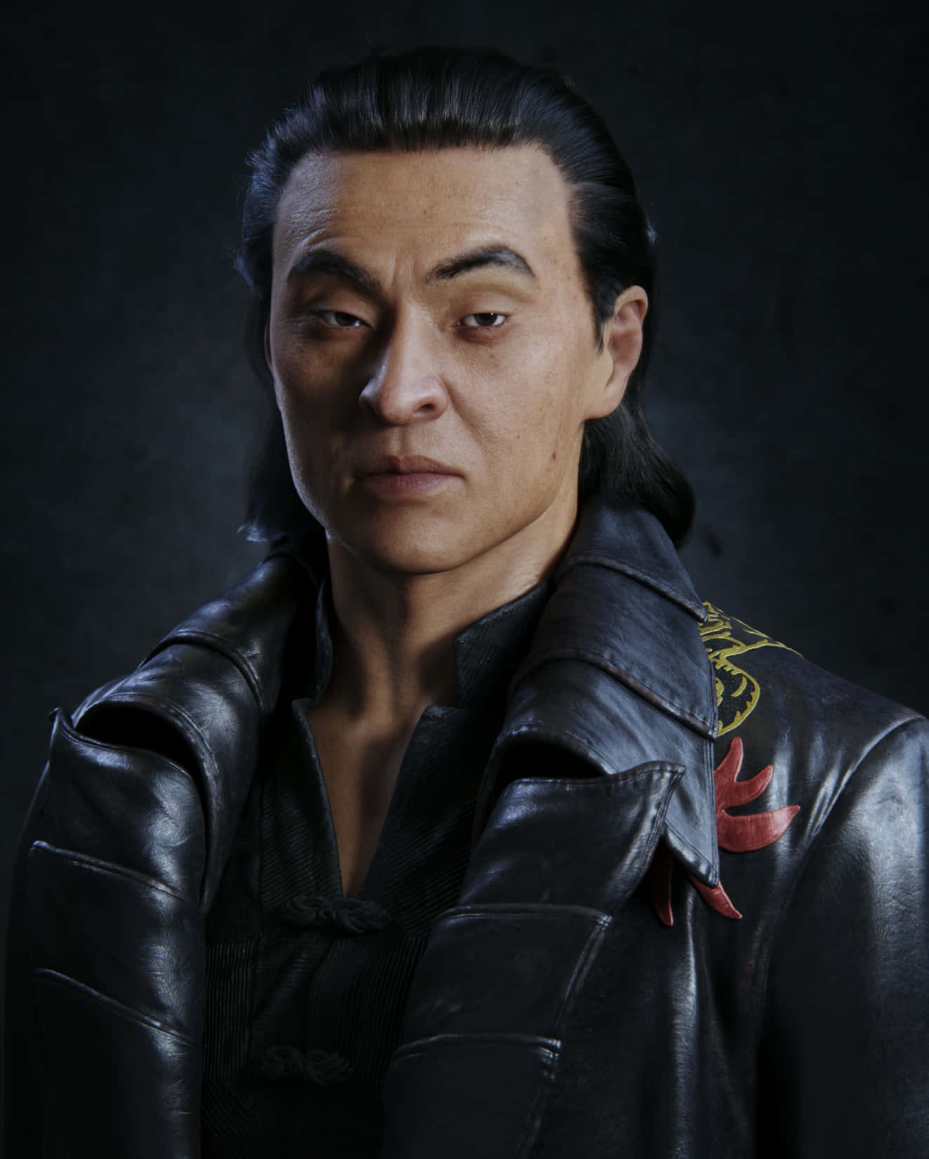 Mortal Kombat Shang Tsung 桌布 壁紙 — 一個嚴肅的黑長髮男人，穿著一件細節豐富的黑色皮夾克，帶有紅色和金色刺繡，背景是深色紋理。