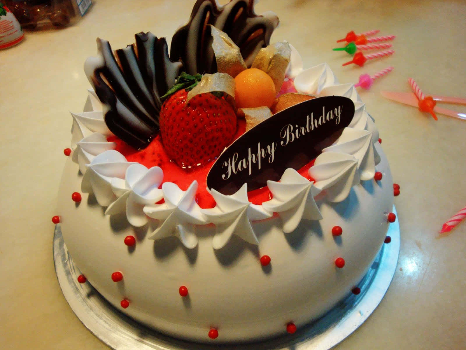  壁紙 — 一個圓形生日蛋糕，上面有鮮奶油、草莓、巧克力和一塊「Happy Birthday」牌。