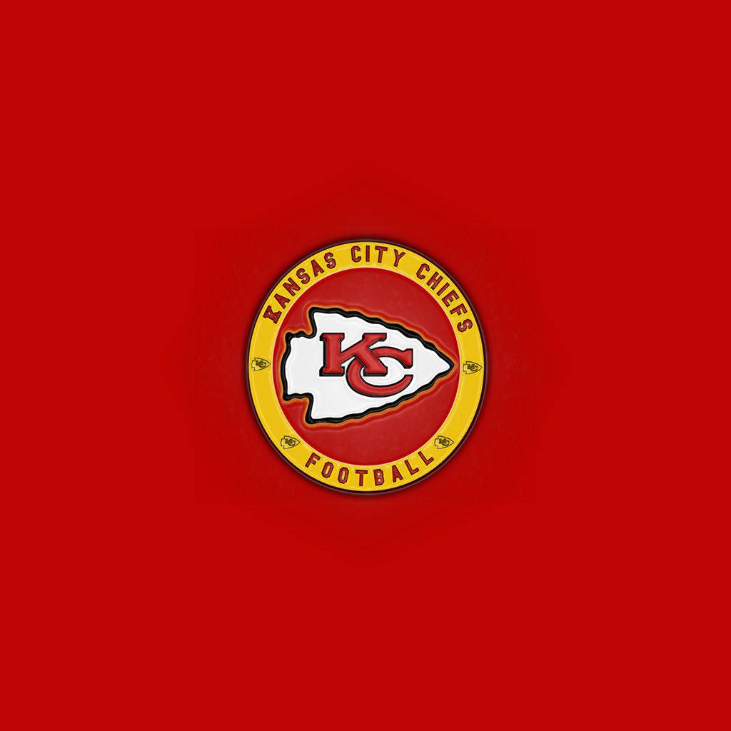 Kc Chiefs 桌布 壁紙 — 一個圓形的堪薩斯城酋長隊美式足球標誌別針，居中放置在純紅色背景上。