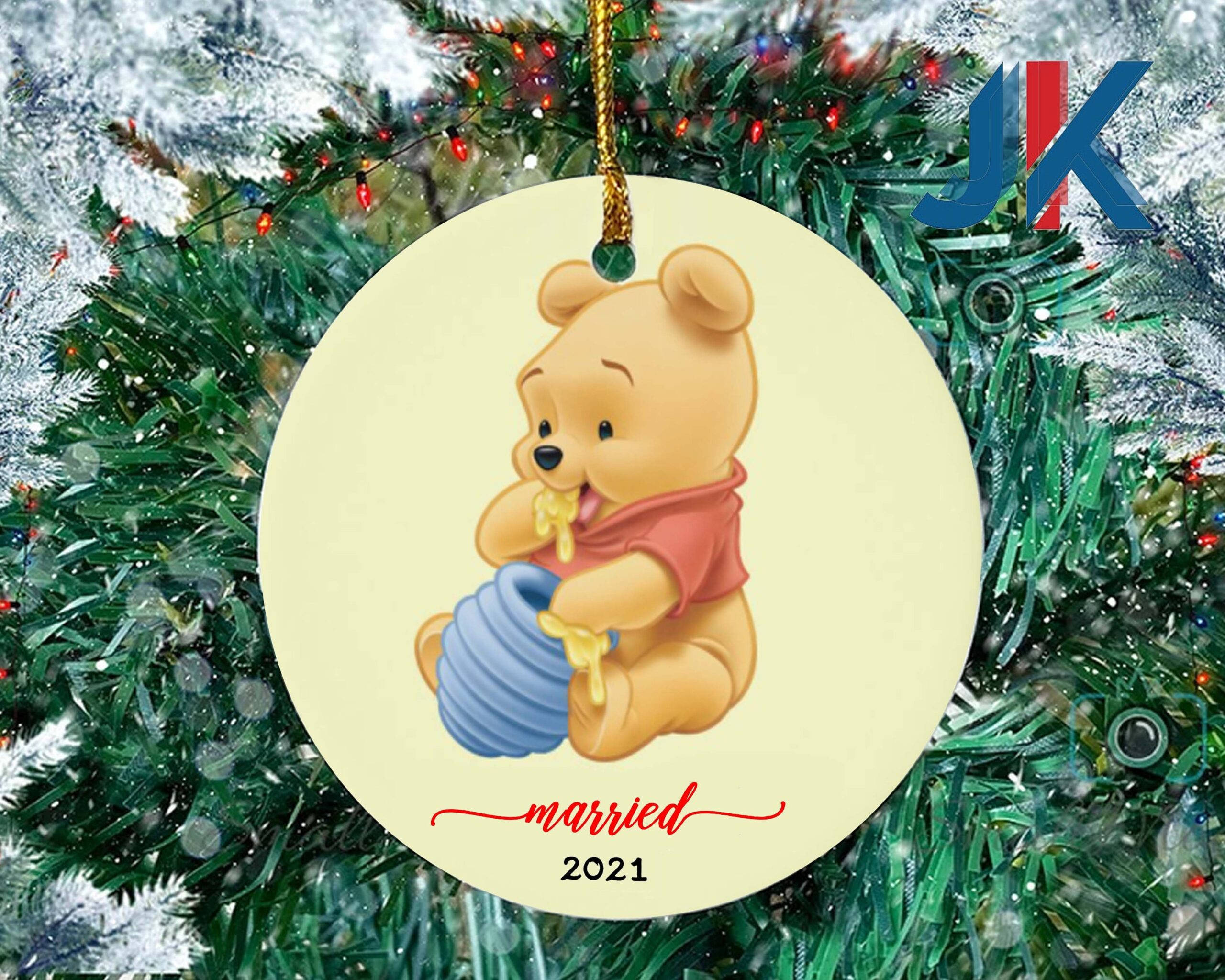Winnie The Pooh Christmas 桌布 壁紙 — 一個圓形聖誕裝飾，小熊維尼拿著一個蜂蜜罐，上面寫著 'married 2021'，掛在佈滿雪的松樹枝上，伴隨著燈光。
