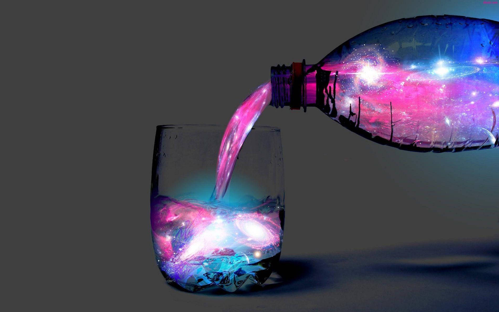 水 桌布 壁紙 — 一個在宇宙粉紅和藍色中旋轉的星系從瓶子倒入玻璃杯中，背景為深灰色。