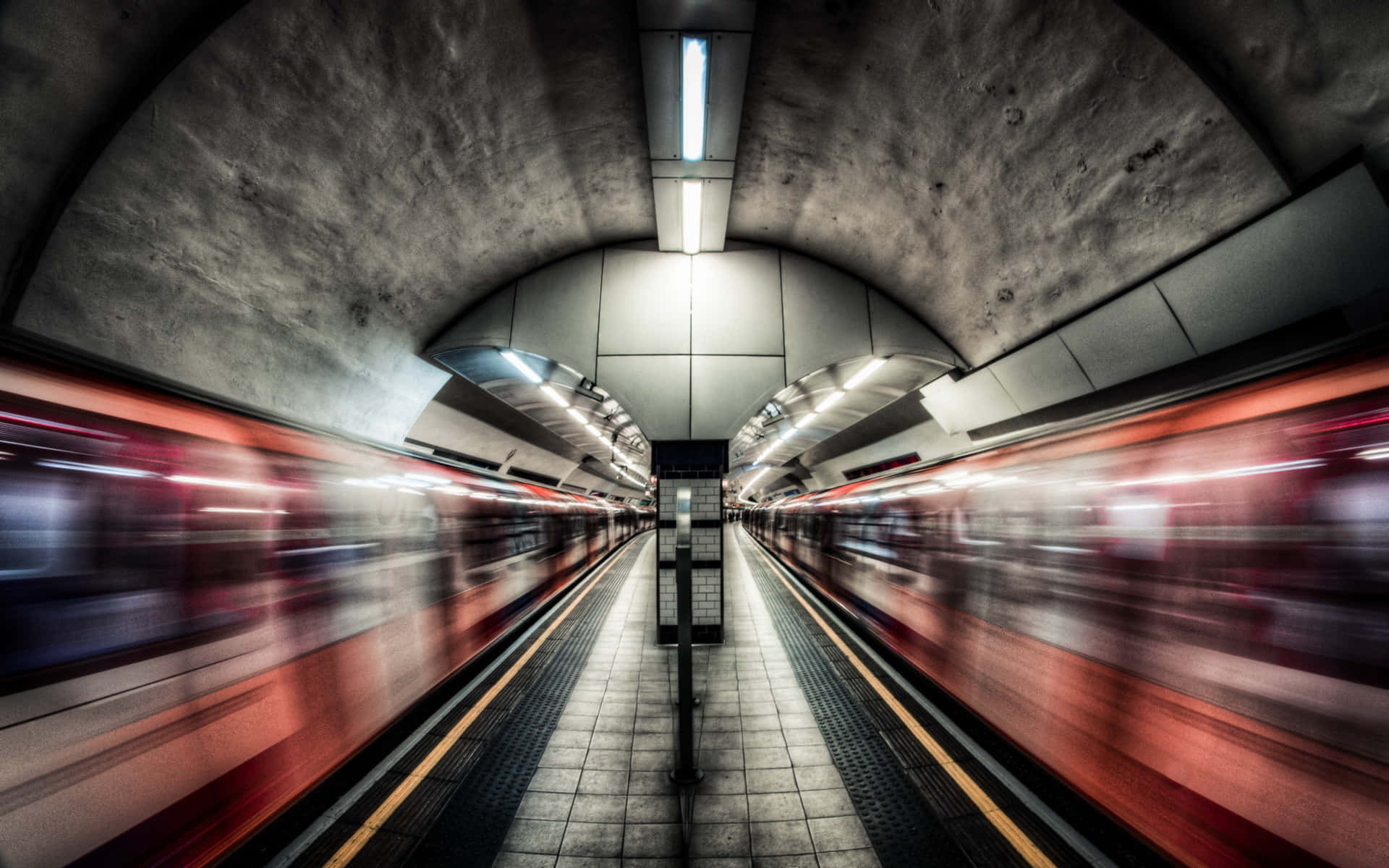 地鐵 桌布 壁紙 — 一個地鐵站，列車在刺眼的螢光燈下以紅色線條模糊駛過。
