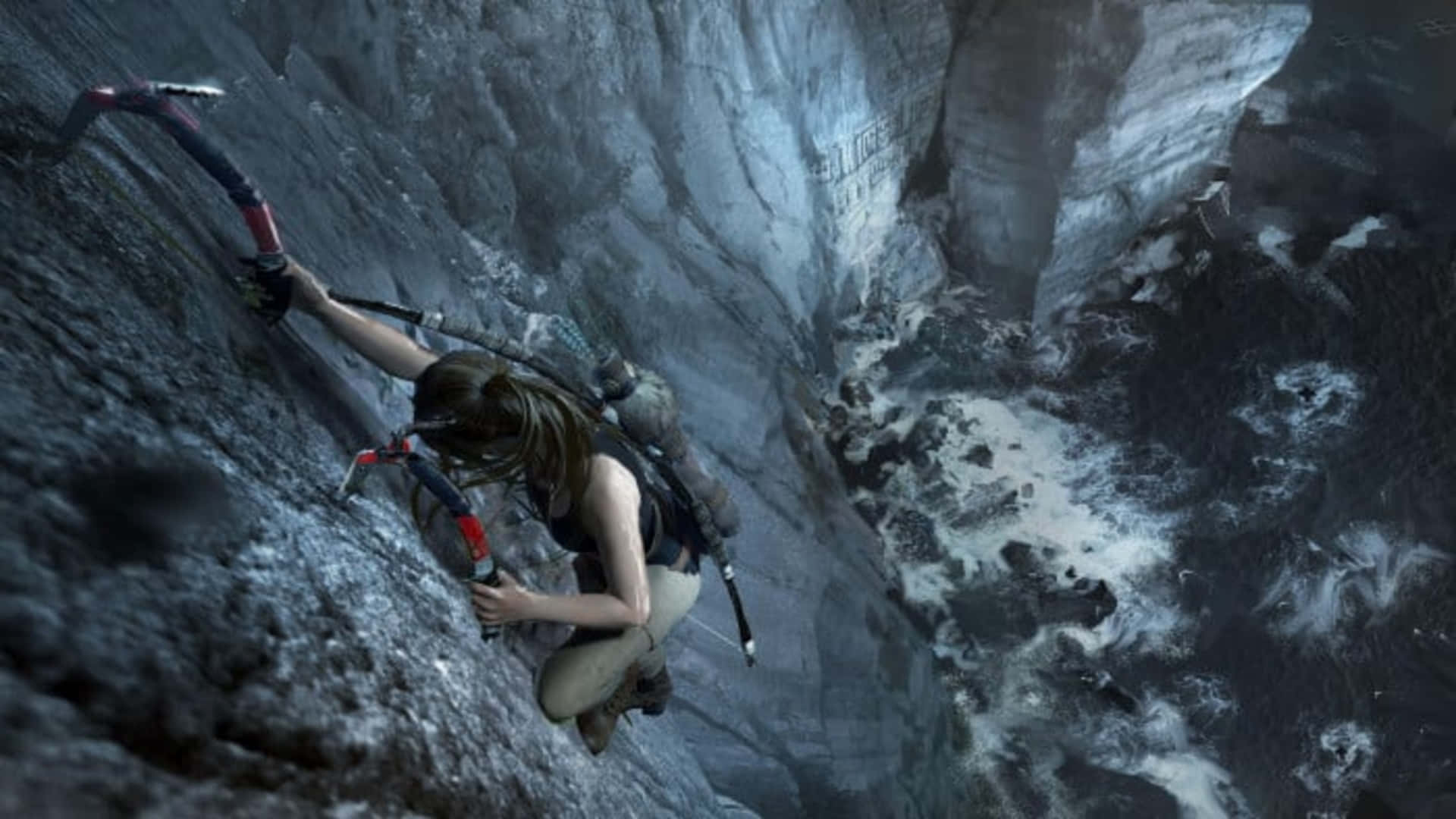 1080p Shadow Of The Tomb Raider 桌布 壁紙 — 一個堅定的冒險家正用冰斧攀登陡峭的冰崖，下方是咆哮的冰川。