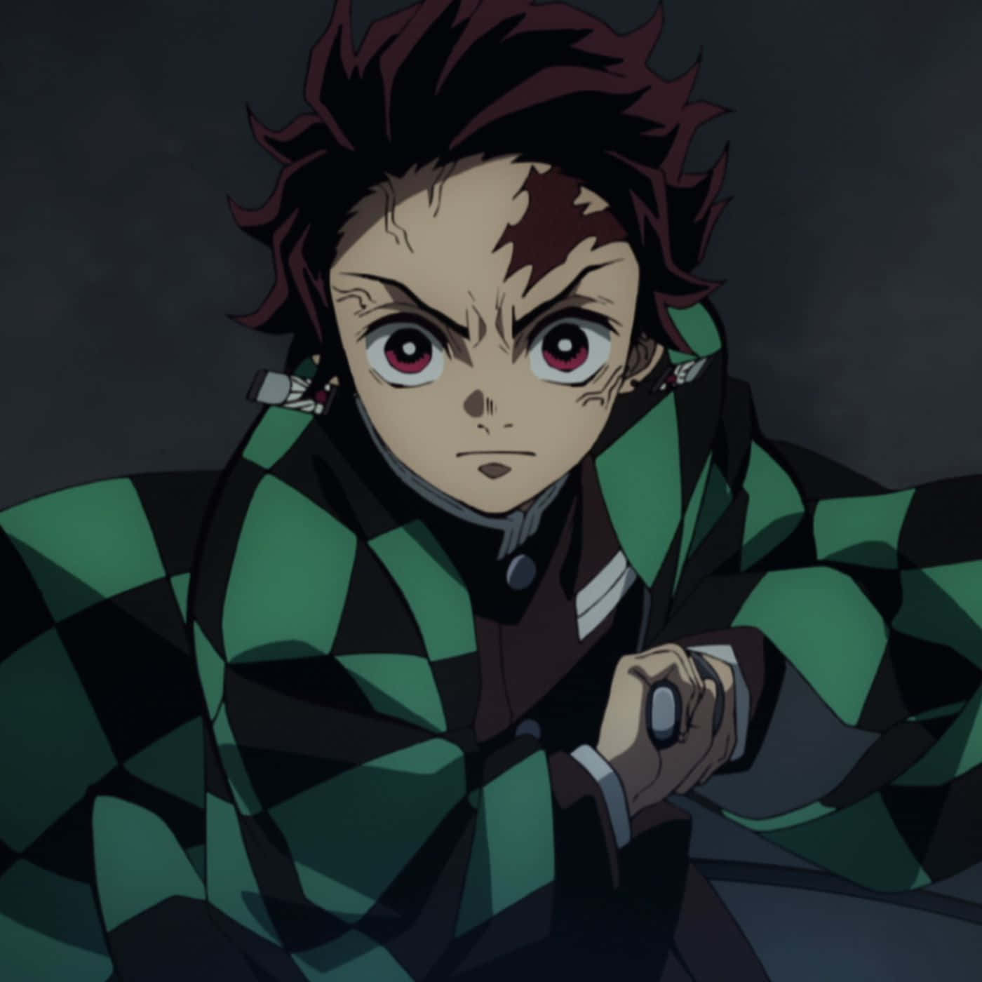 Demon Slayer Characters 桌布 壁紙 — 一個堅定的動漫男孩，有著尖刺的紅髮和綠色格子紋和服，在黑暗、強烈的特寫中握著一把劍。