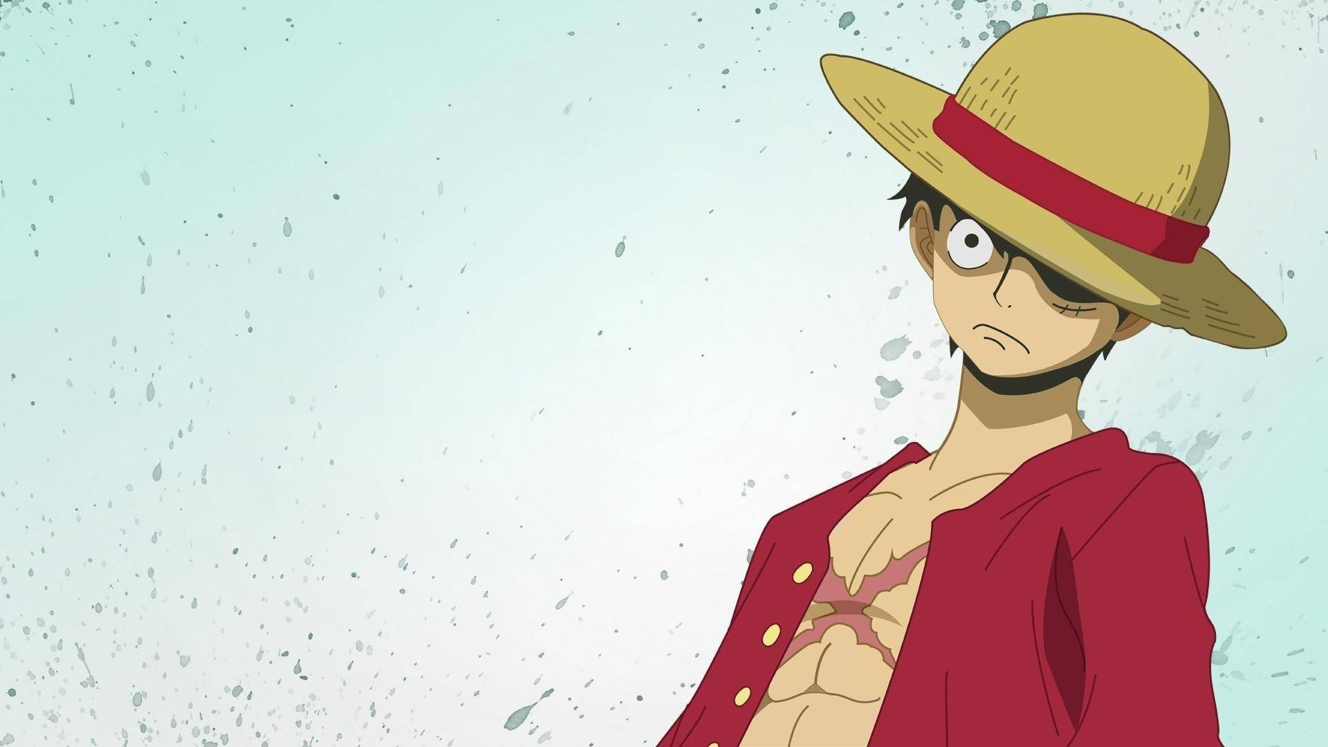 Luffy 桌布 壁紙 — 一個堅定的動畫海盜，戴著草帽和紅色外套，站在有斑點的淺藍色背景前。