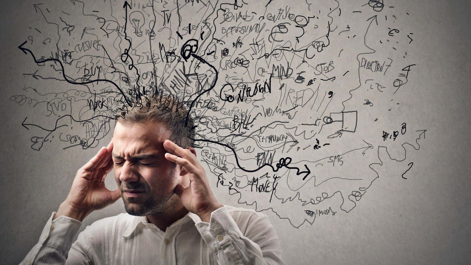 stressed 桌布 壁紙 — 一個壓力大的男人抓著自己的頭，混亂的塗鴉和文字從他的頭皮向著素牆爆炸出來。