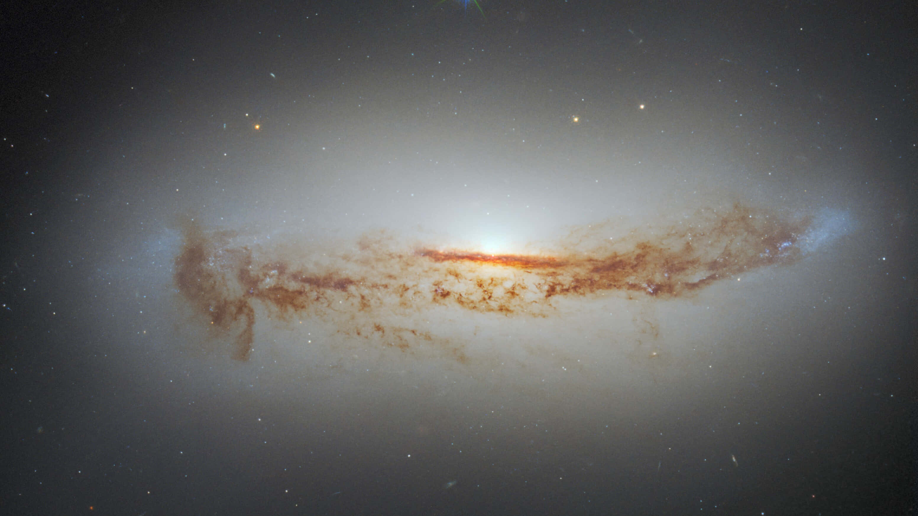 Black Hole Hubble Telescope 桌布 壁紙 — 一個壯麗的螺旋星系在佈滿星星的宇宙虛空中散發出溫暖的橙色和白色色調。