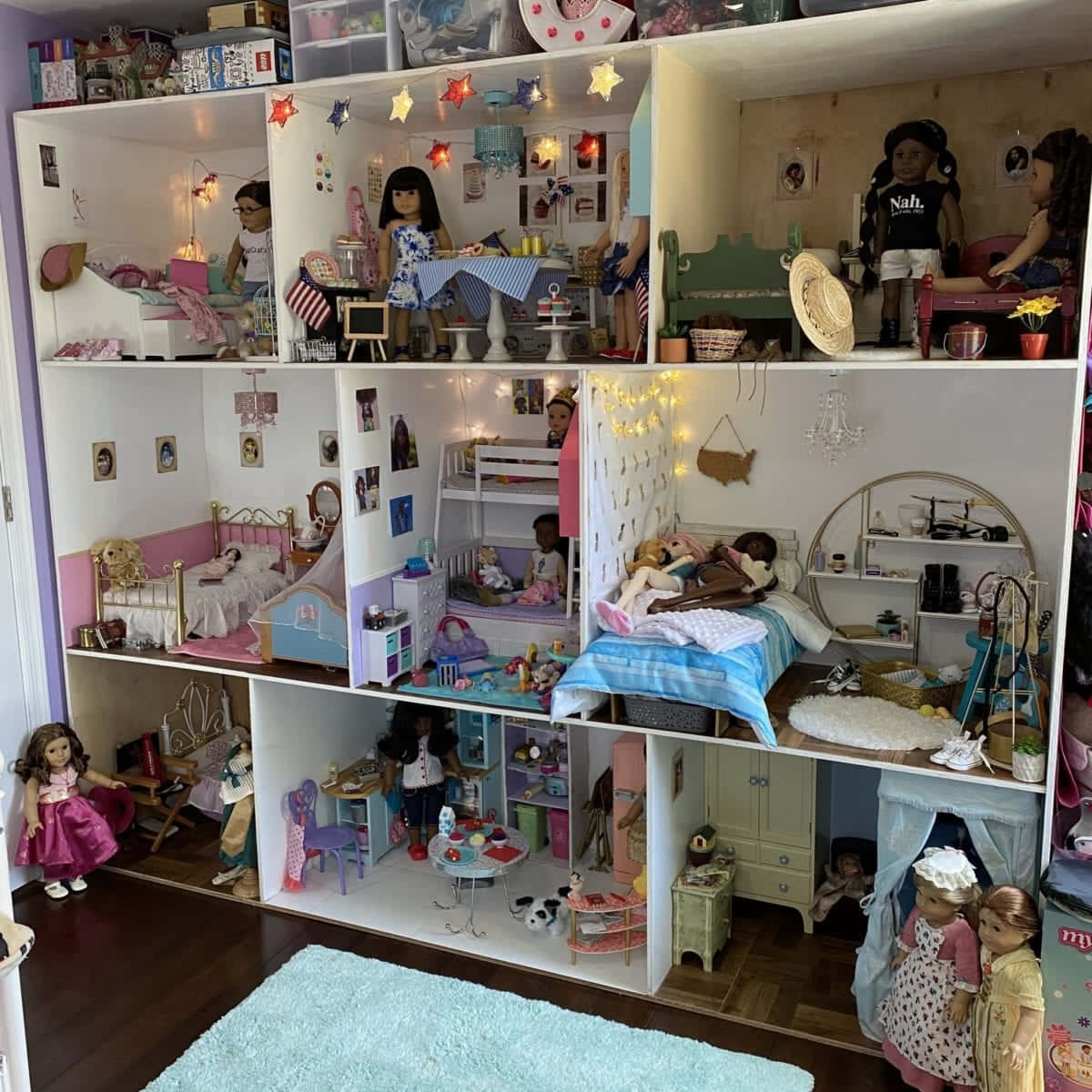 american girl 桌布 壁紙 — 一個多層娃娃屋，內有詳細的房間和各種場景中的娃娃，由仙女燈照亮。