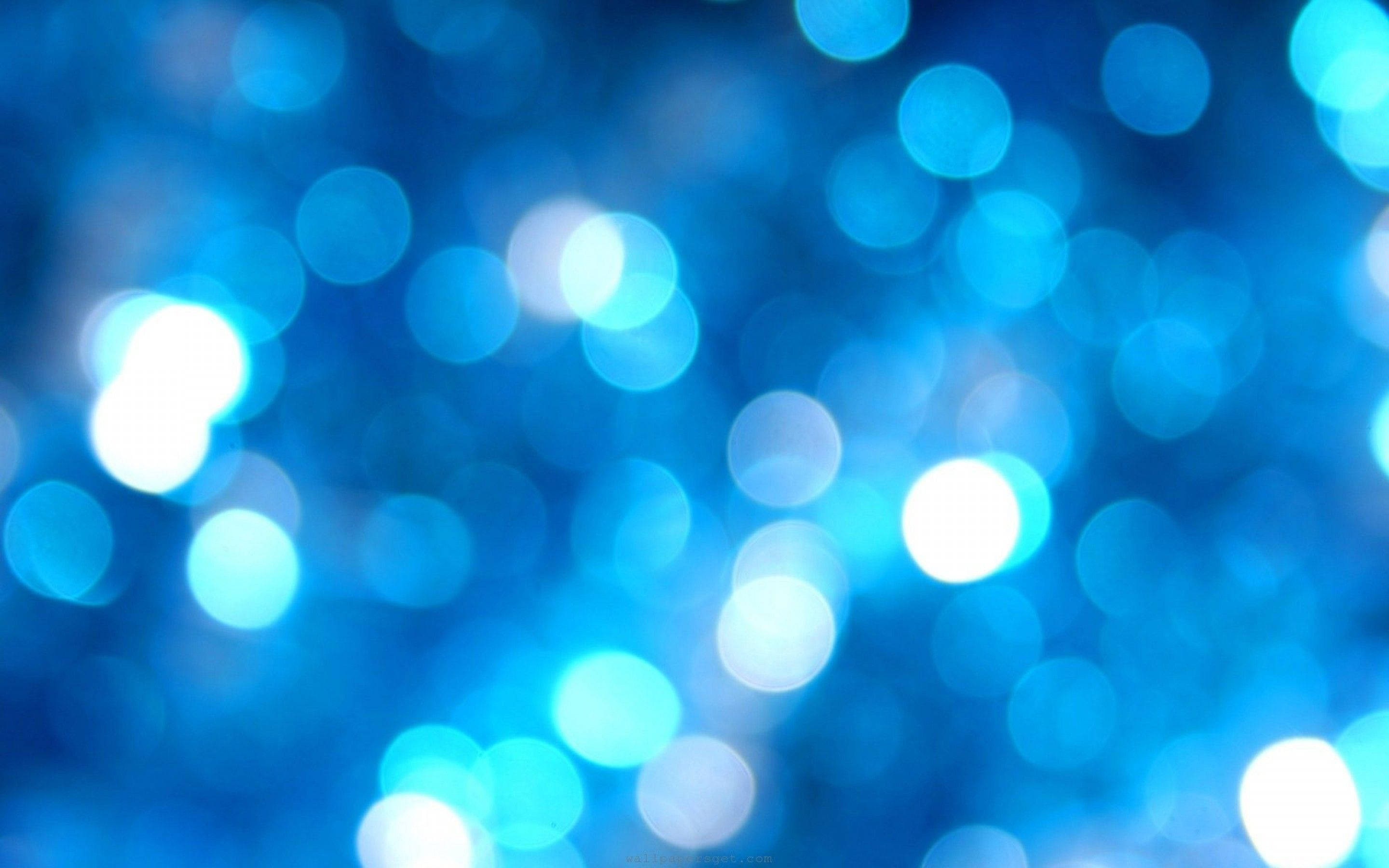 Blue Aesthetic Desktop 桌布 壁紙 — 一個夢幻般的發光藍色散景燈光場，在深藍色背景上柔和模糊。