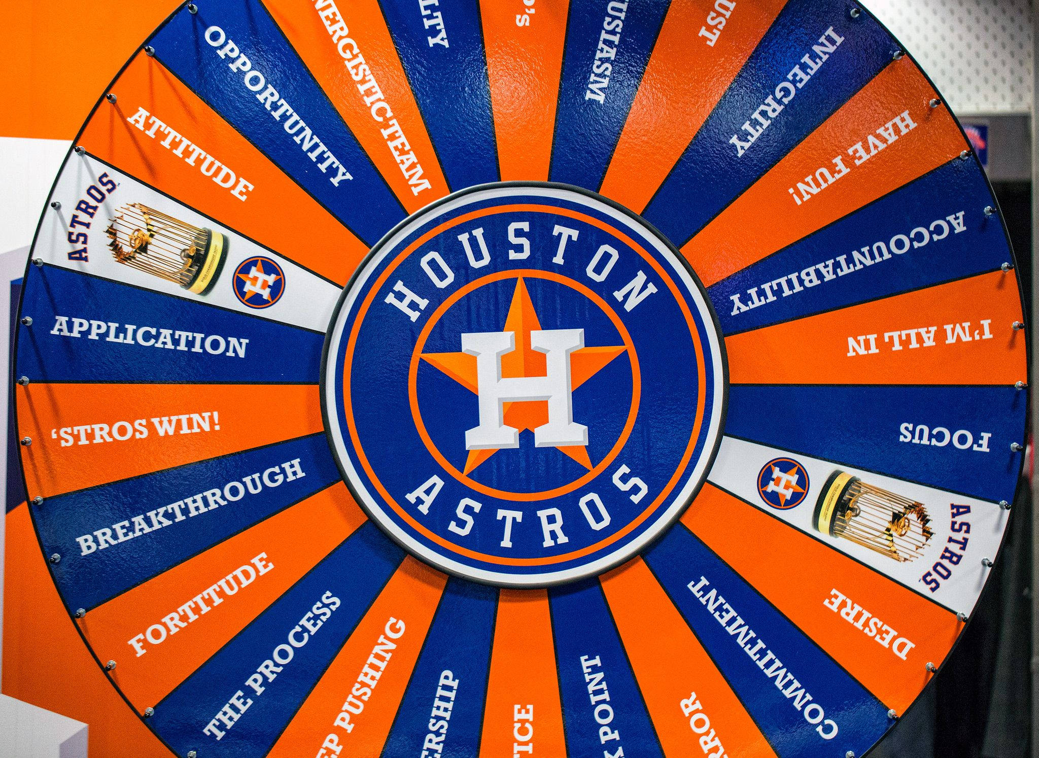 Astros 桌布 壁紙 — 一個大型圓形休士頓太空人隊激勵輪盤，橙色和藍色區塊顯示「attitude」、「accountability」和「focus」等詞語，圍繞中央的球隊標誌。