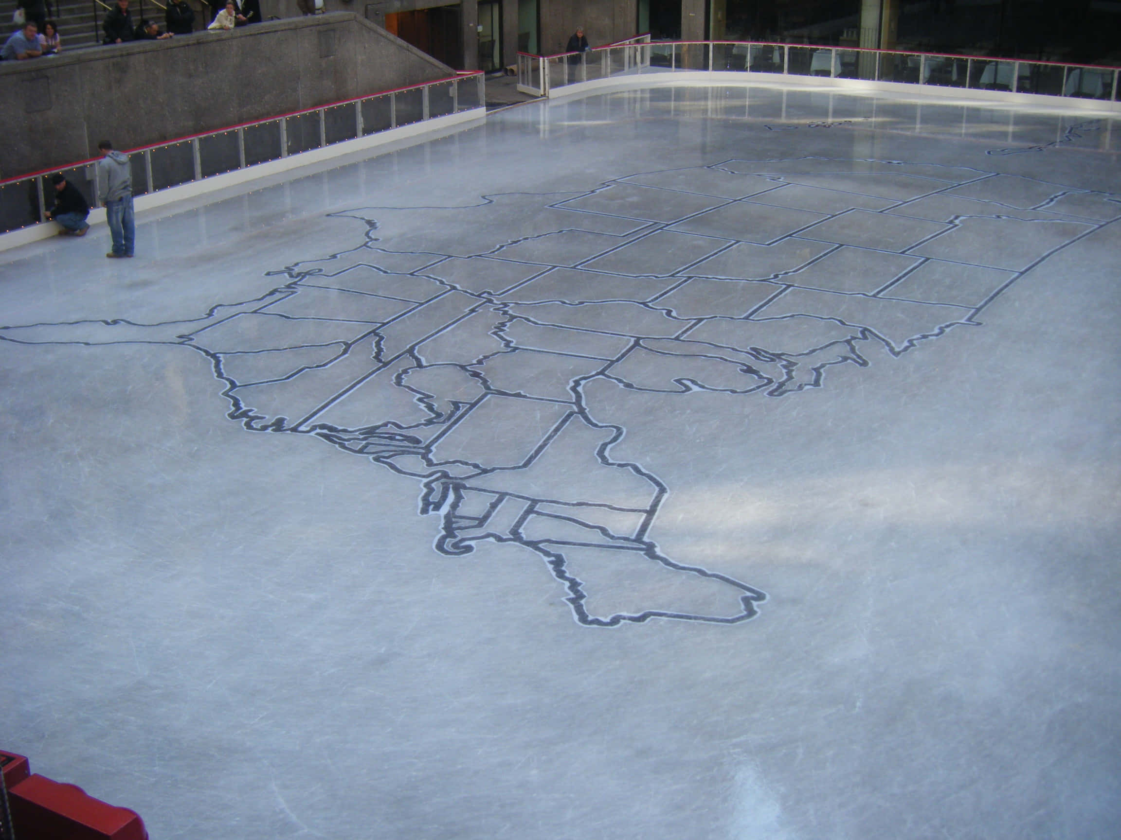 Ice Rink 桌布 壁紙 — 一個大型室內溜冰場表面以深色線條繪製了美國的詳細輪廓。